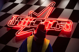 Figure in colorful coat facing red neon star with Chinese characters on black and white checkered floor