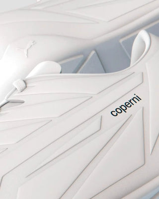 Close-up of white Puma Coperni sneakers with textured design and black Coperni logo