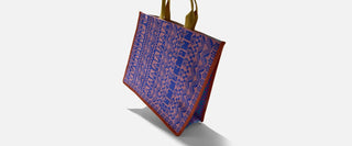 Blue and pink patterned tote bag with brown trim and yellow handles on white background