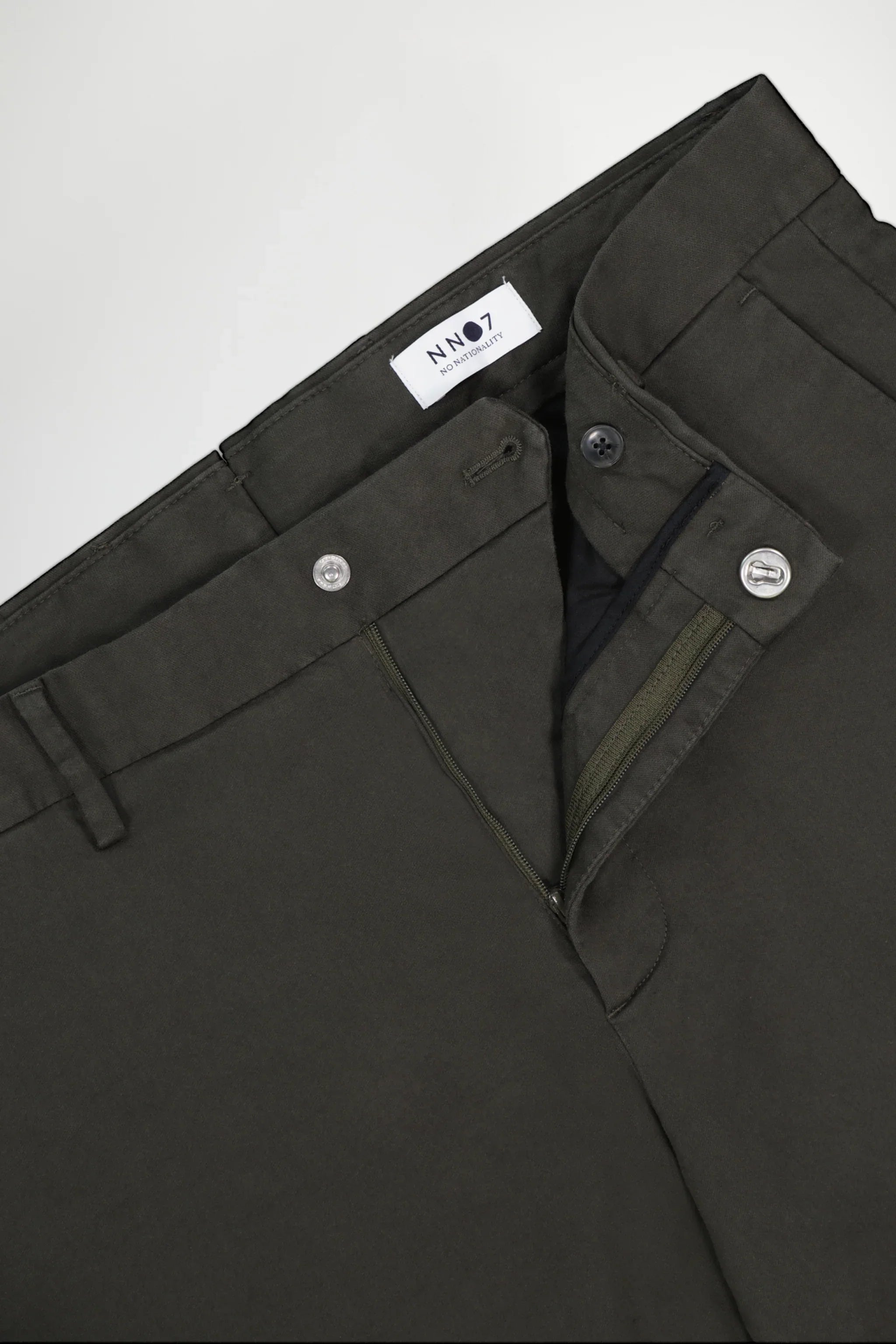 Close-up of dark green NN07 men's pants with zipper and button closure detail