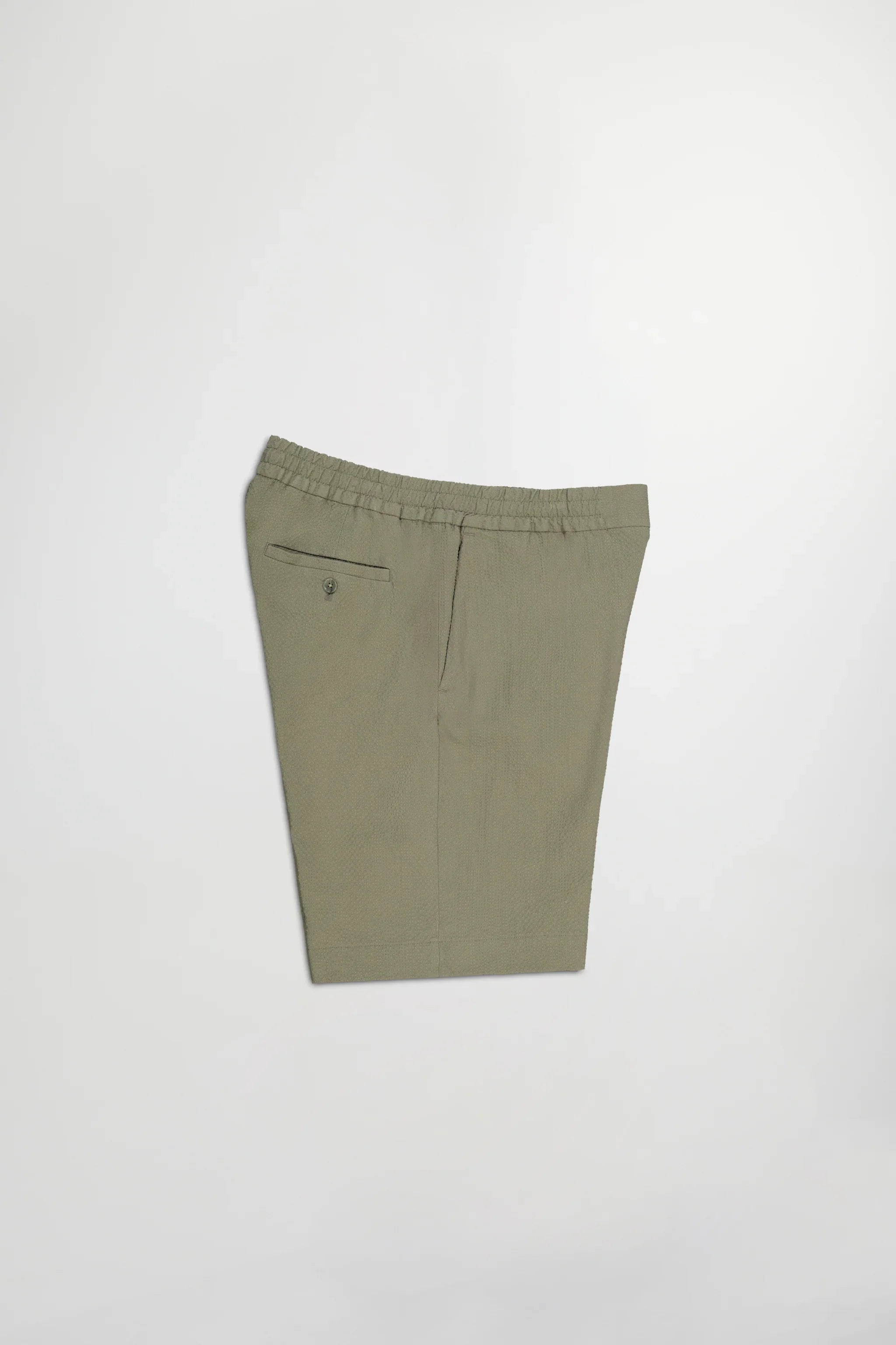 Folded olive green shorts with elastic waistband and buttoned back pocket on white background