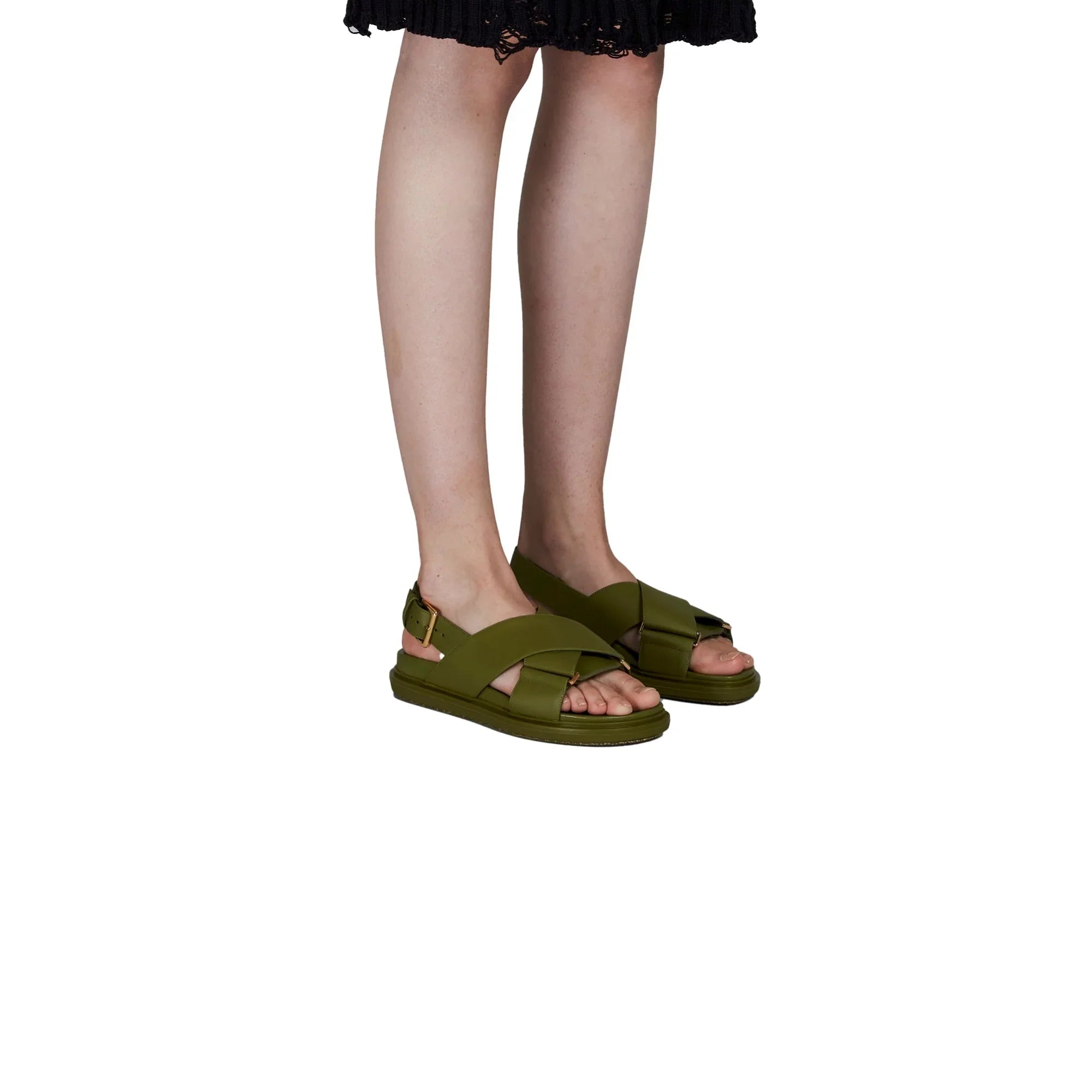 Person wearing olive green open-toe crisscross strap flat sandals with gold buckle detail