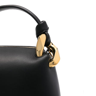 Black handbag with a gold clasp on a white background