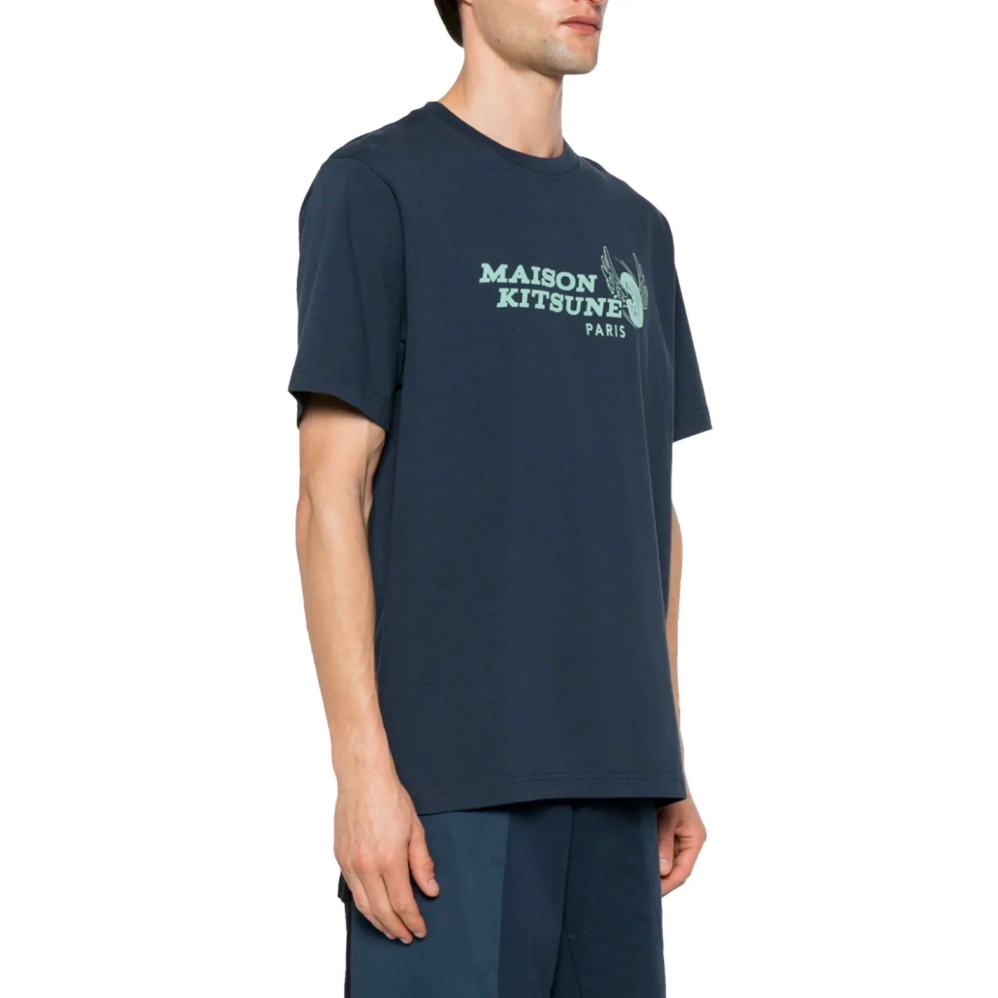 Side view of man wearing navy blue Maison Kitsune Paris racing wheels graphic t-shirt and matching shorts