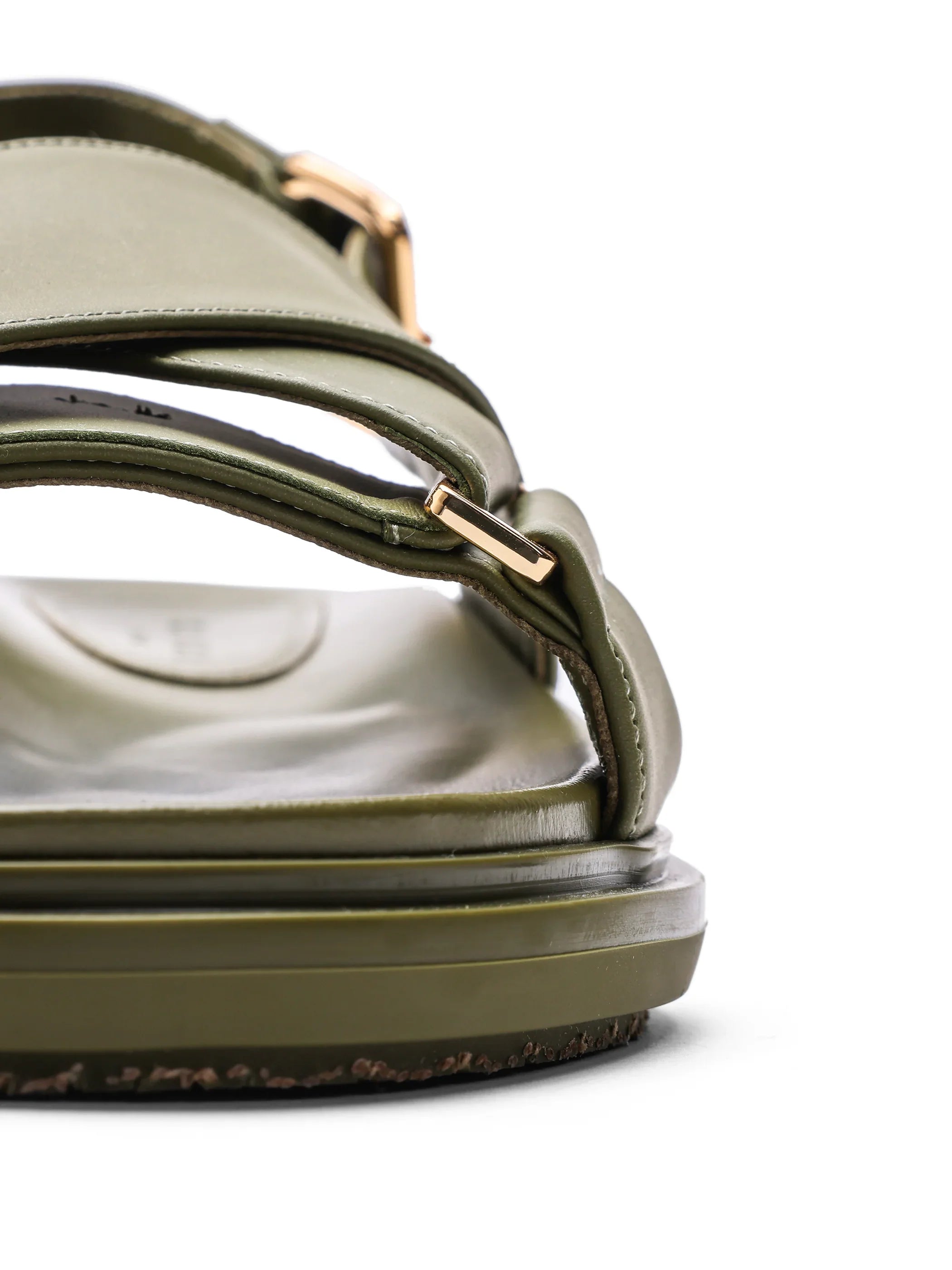 Close-up of olive green sandal with gold buckle and cushioned sole on white background