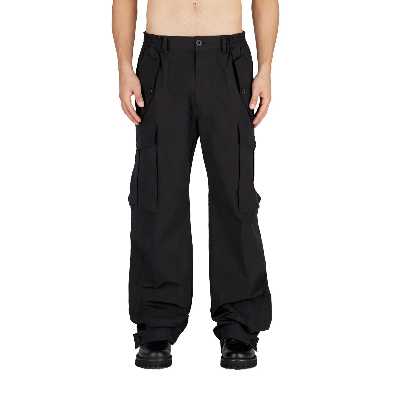 Front view of man wearing black cargo pants with multiple pockets and black boots