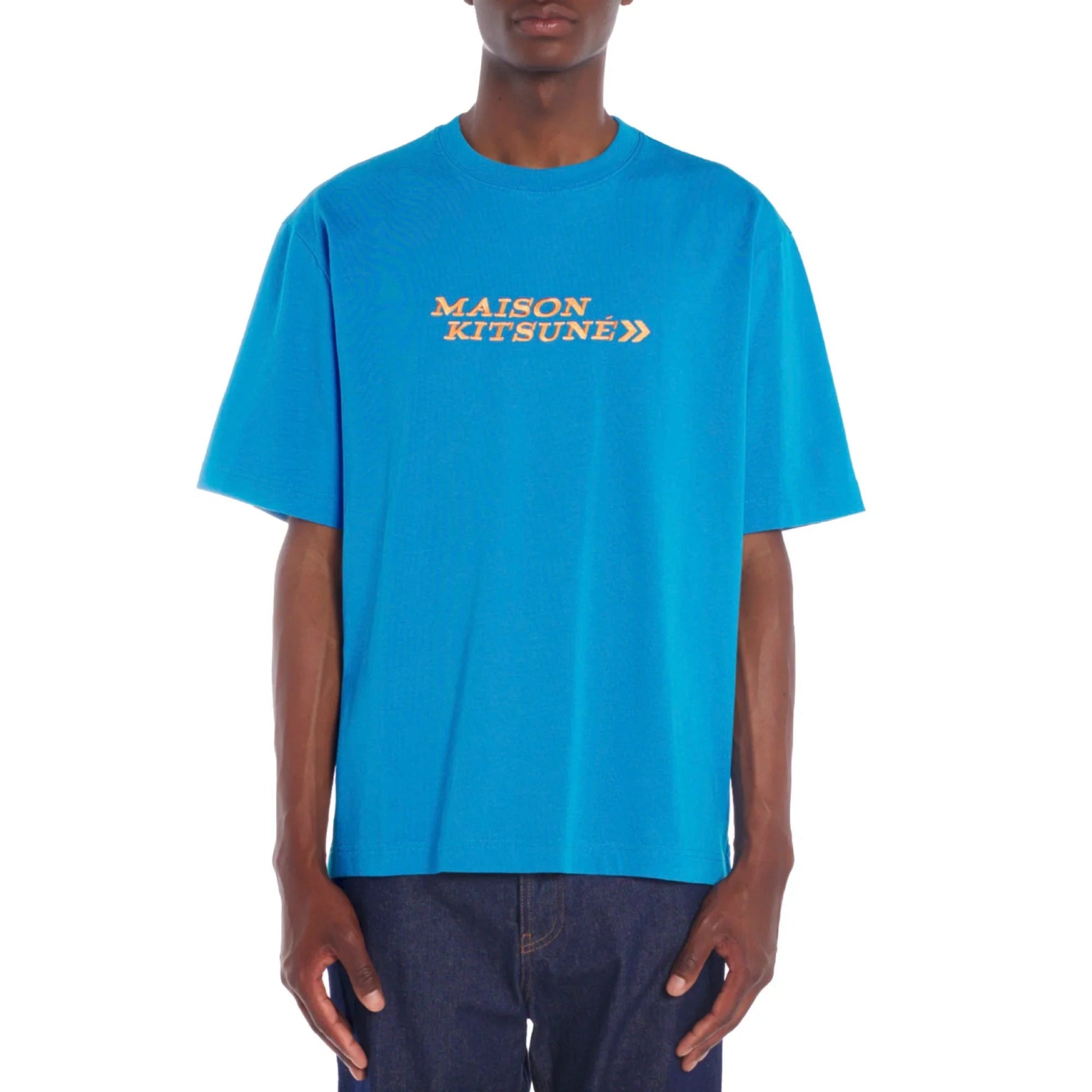 Blue Maison Kitsuné t-shirt with orange logo worn by male model, paired with dark jeans
