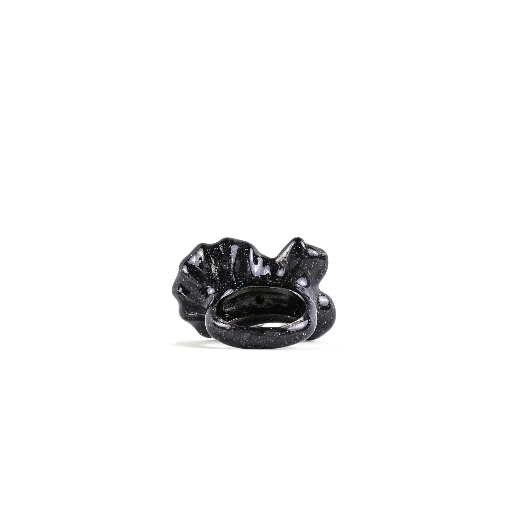 Glossy black sculptural ring with a wavy, textured design on a white background