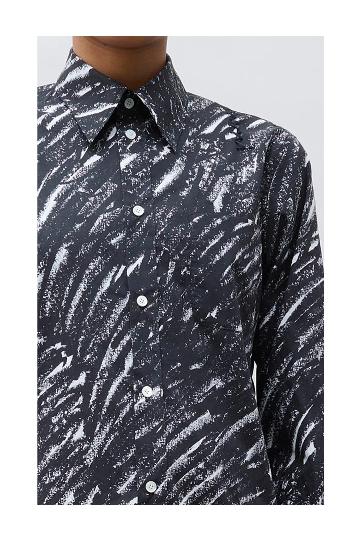 Close-up of black button-up shirt with white abstract brushstroke pattern and pointed collar