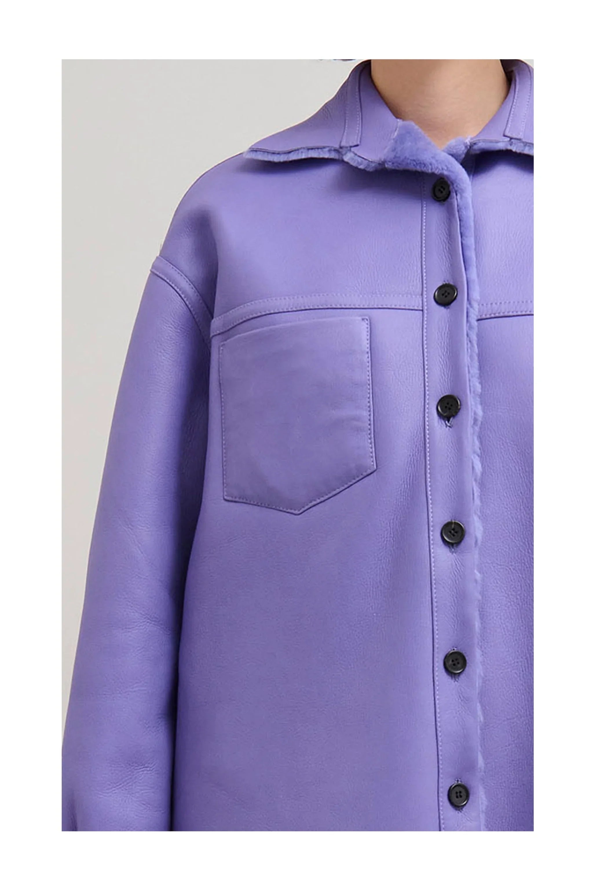 Close-up of a lavender purple leather jacket with front pocket and black buttons