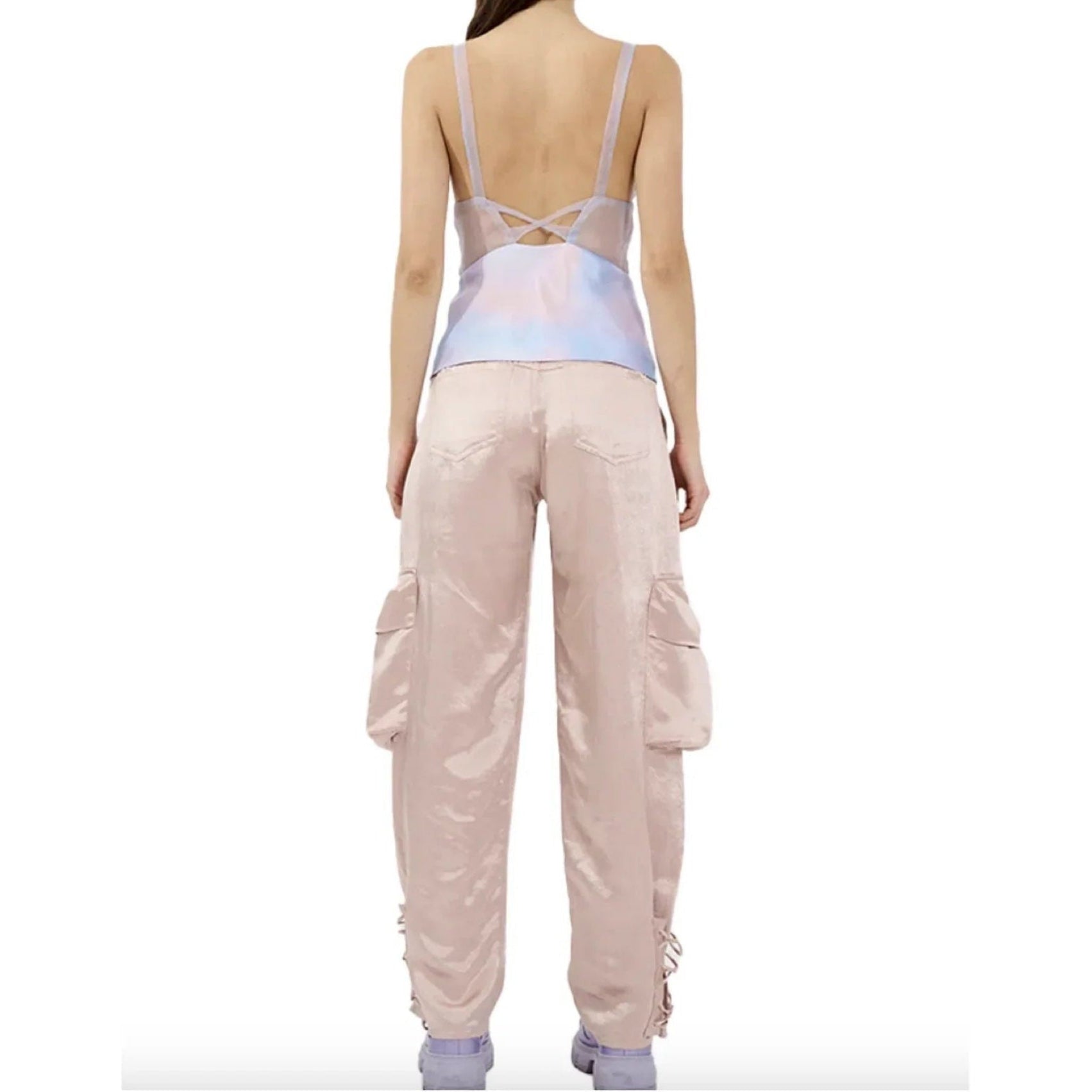 Rear view of woman wearing light pink satin cargo pants with large pockets and lavender top