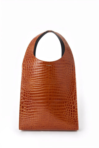 Brown textured bag with black handle on a white background