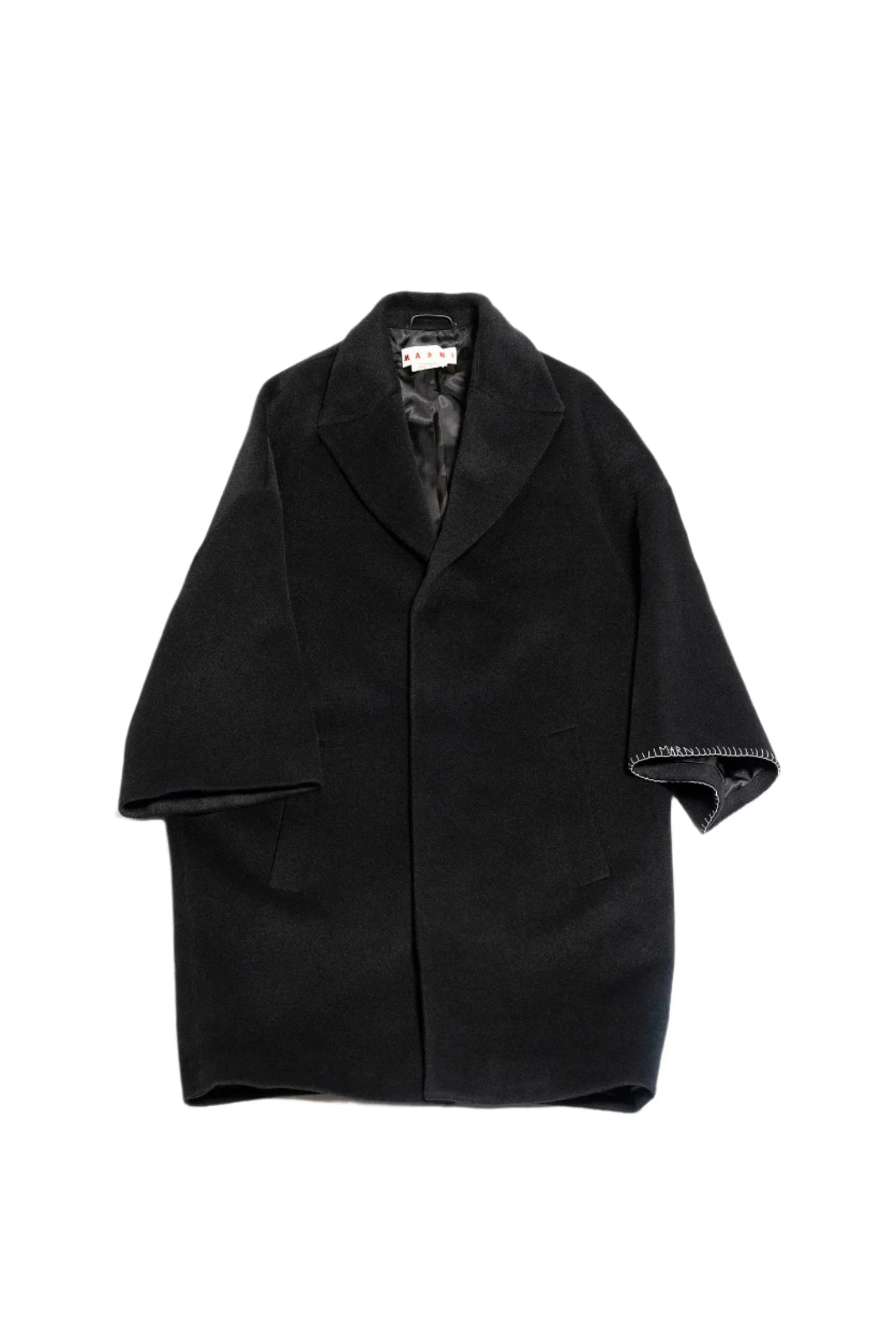 Black oversized wool coat with wide lapels and stitched detailing on sleeve edge, isolated on white