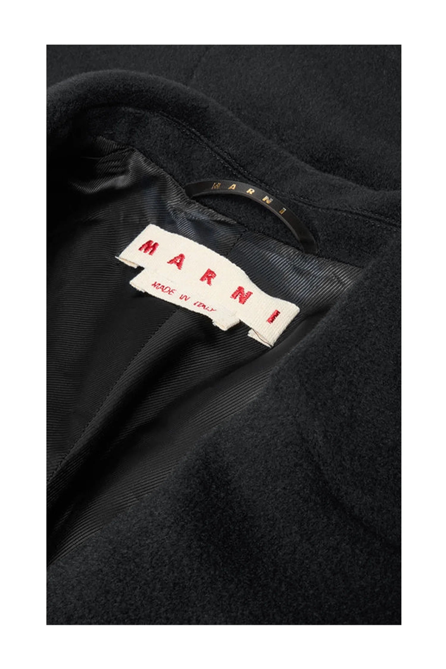 Close-up of black Marni coat label with red text on black silky lining
