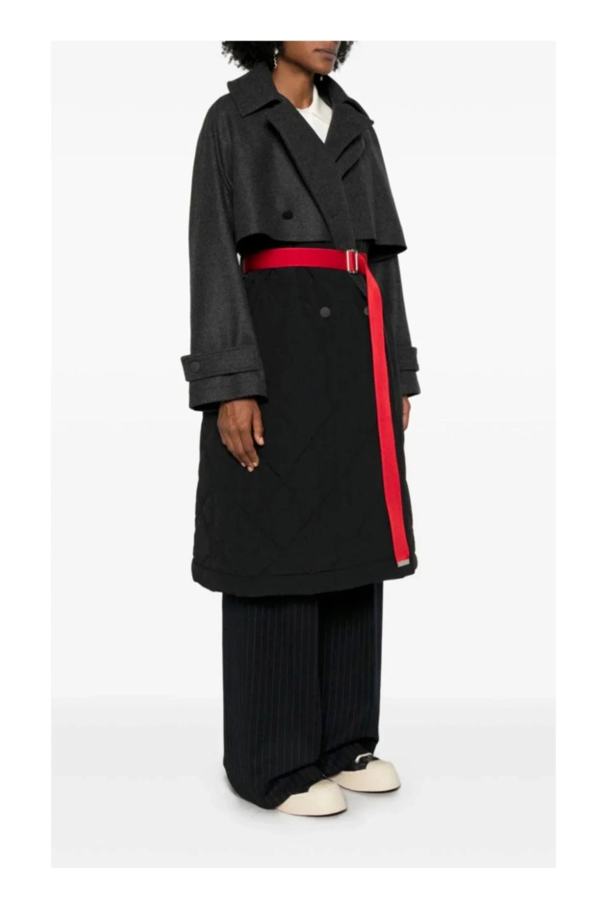 Person wearing a black coat with a red stripe on a white background