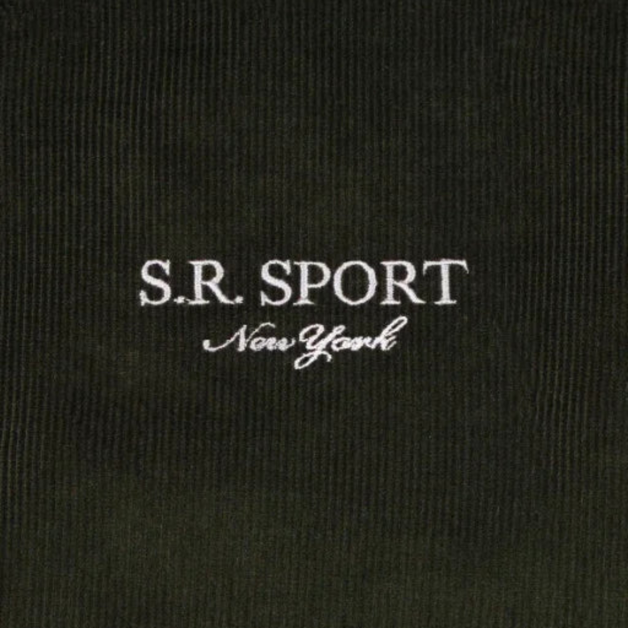 Close-up of black fabric with white embroidered text S.R. SPORT New York