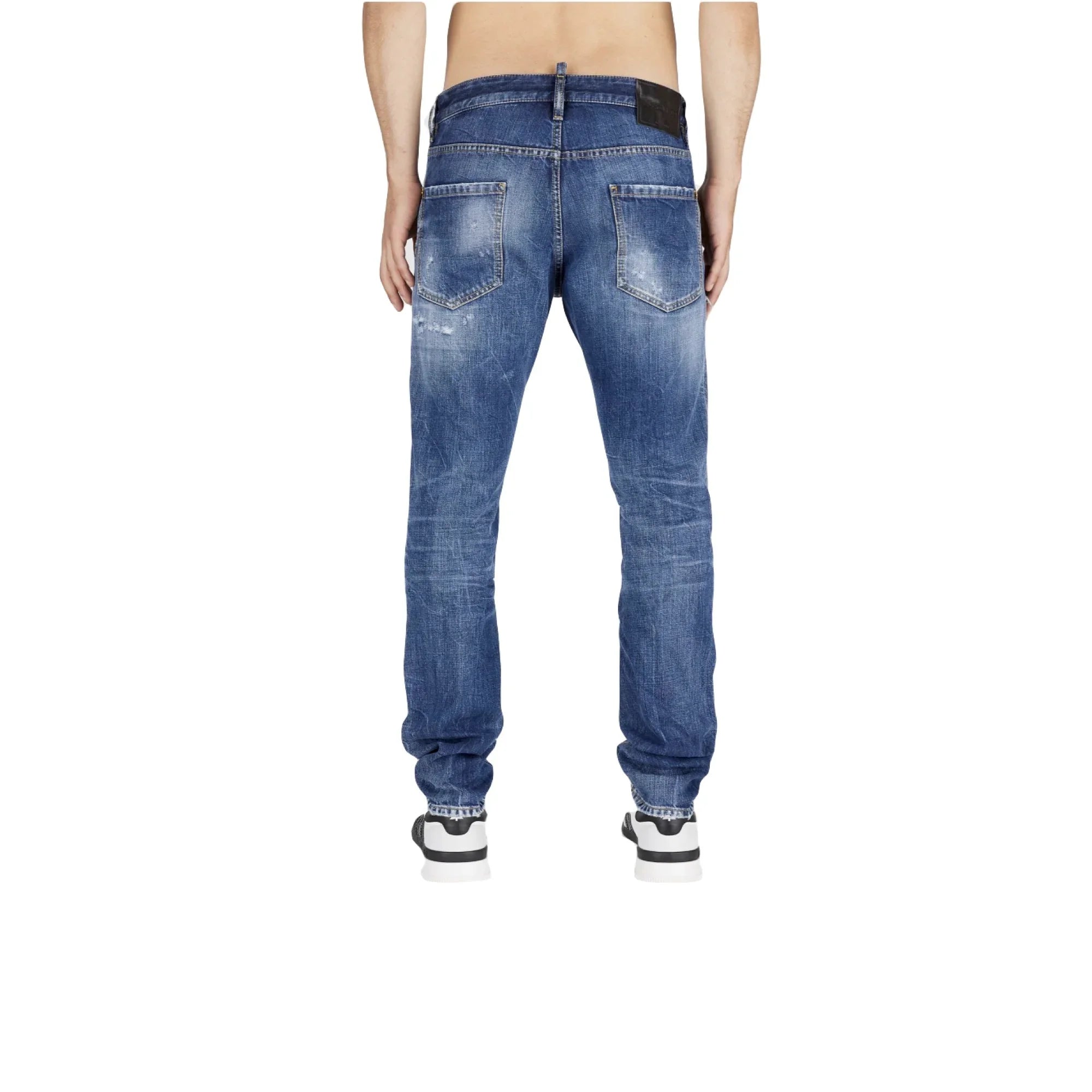 Back view of slim fit distressed blue denim jeans worn by a standing male model on white background