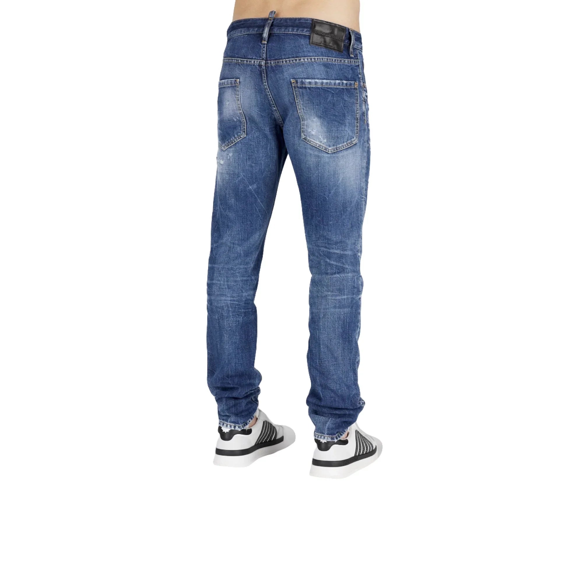 Back view of person wearing faded blue denim jeans and white sneakers on white background