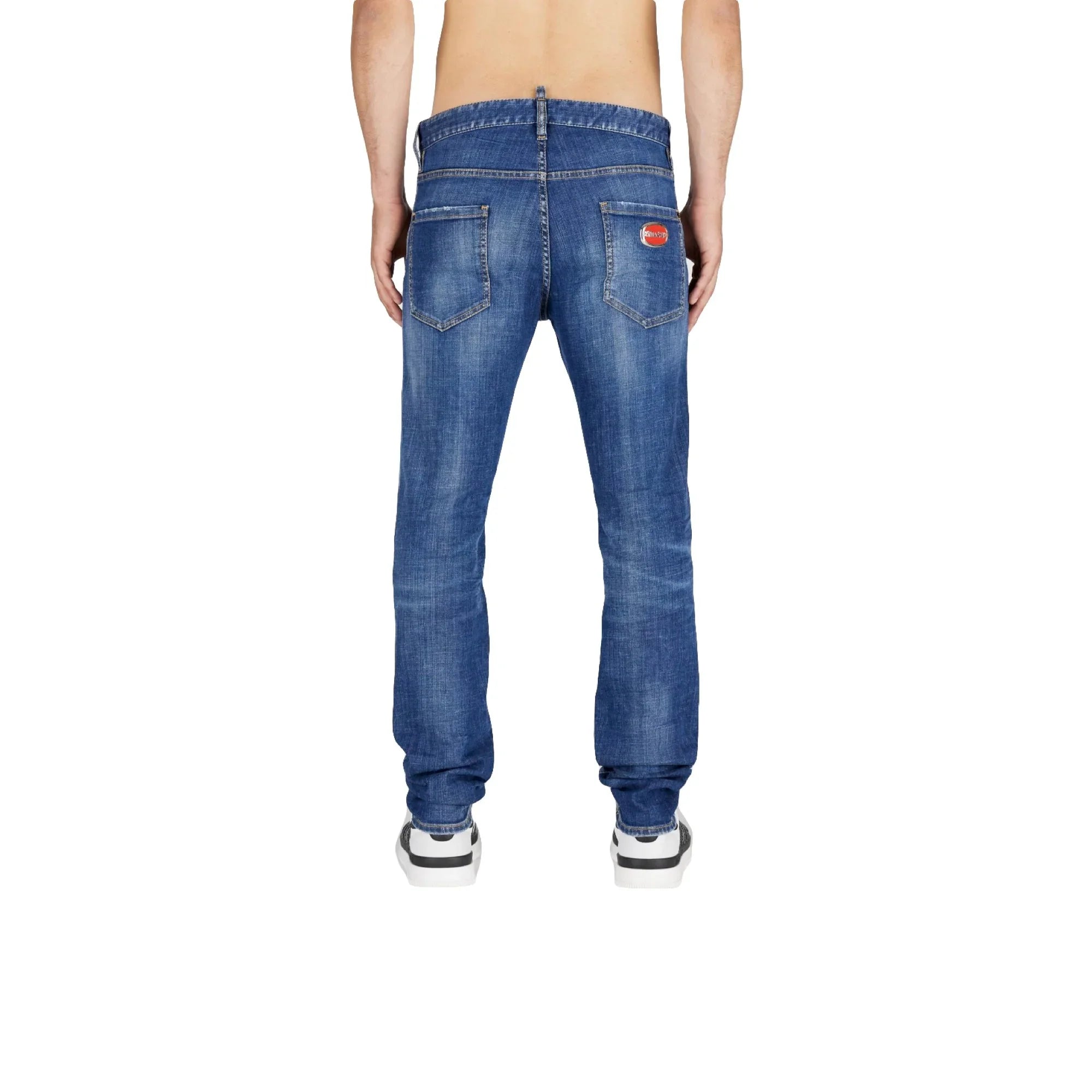 Rear view of man wearing medium blue faded denim jeans with patch logo on right back pocket and white sneakers