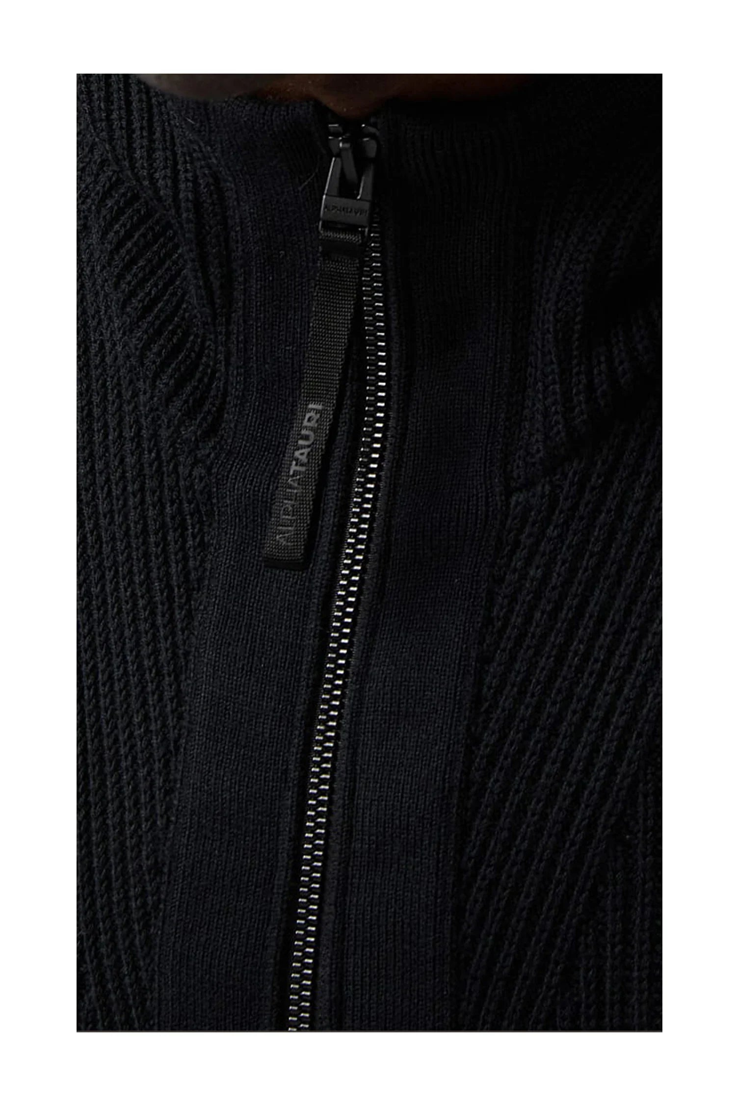 Close-up of black knit sweater with full-length zipper and AlphaTauri branded pull tab