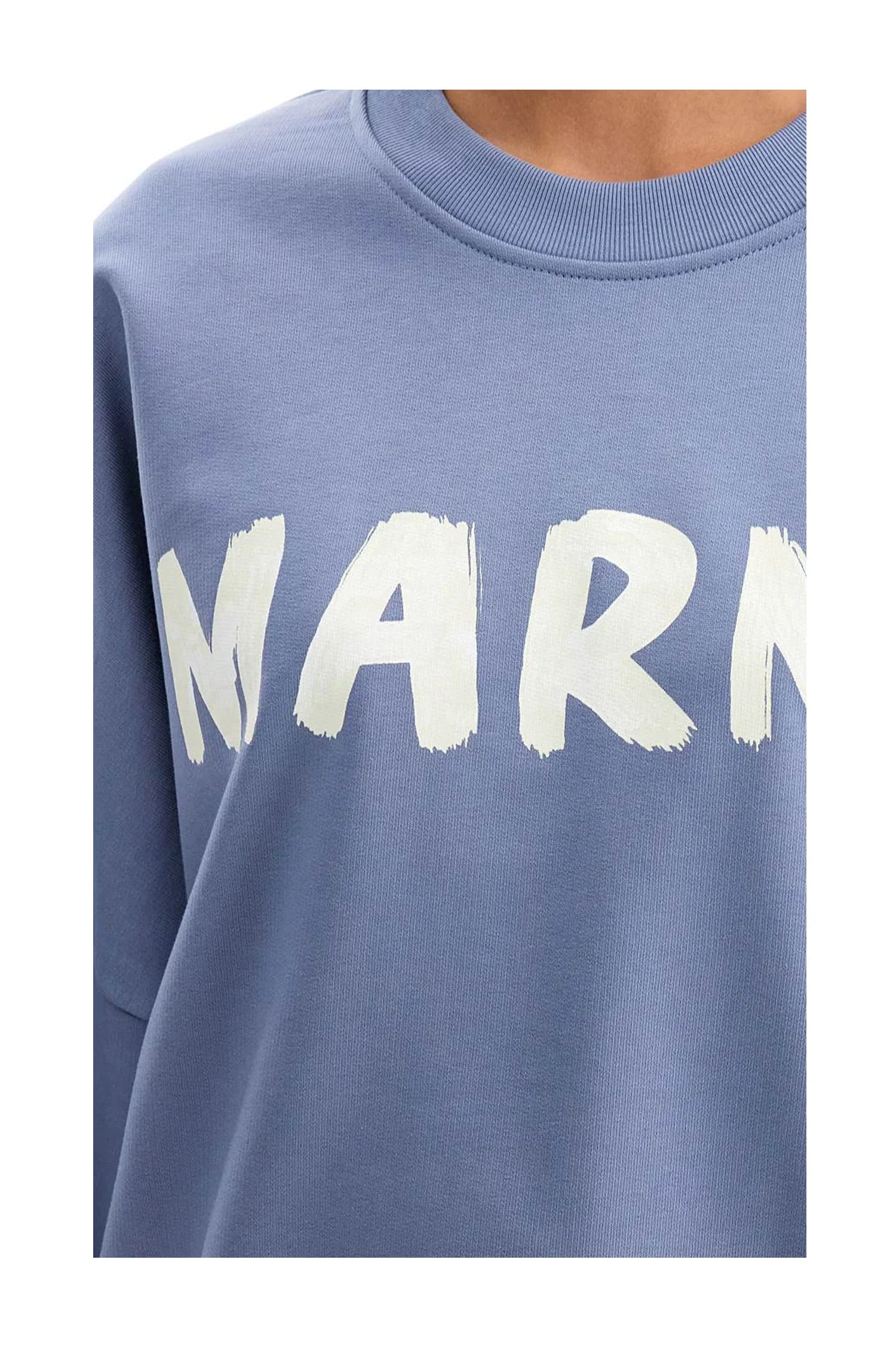 Close-up of blue crewneck sweatshirt with large white painted-style text on chest