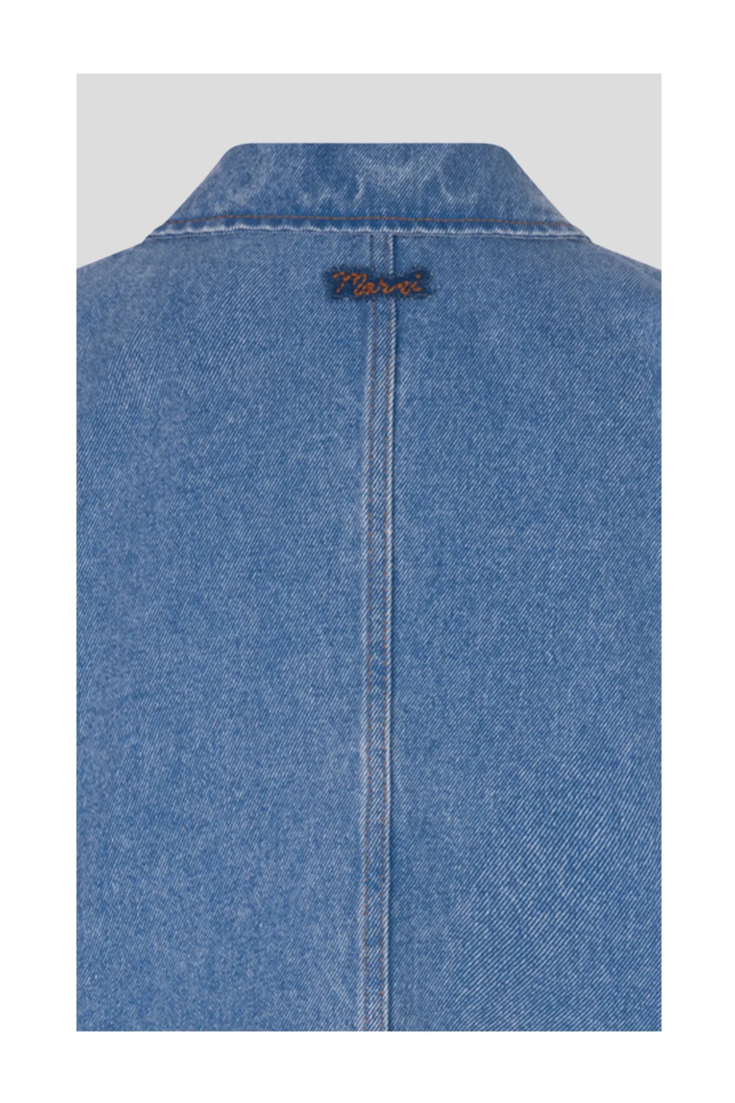Back collar of blue denim jacket with vertical seam and small stitched label