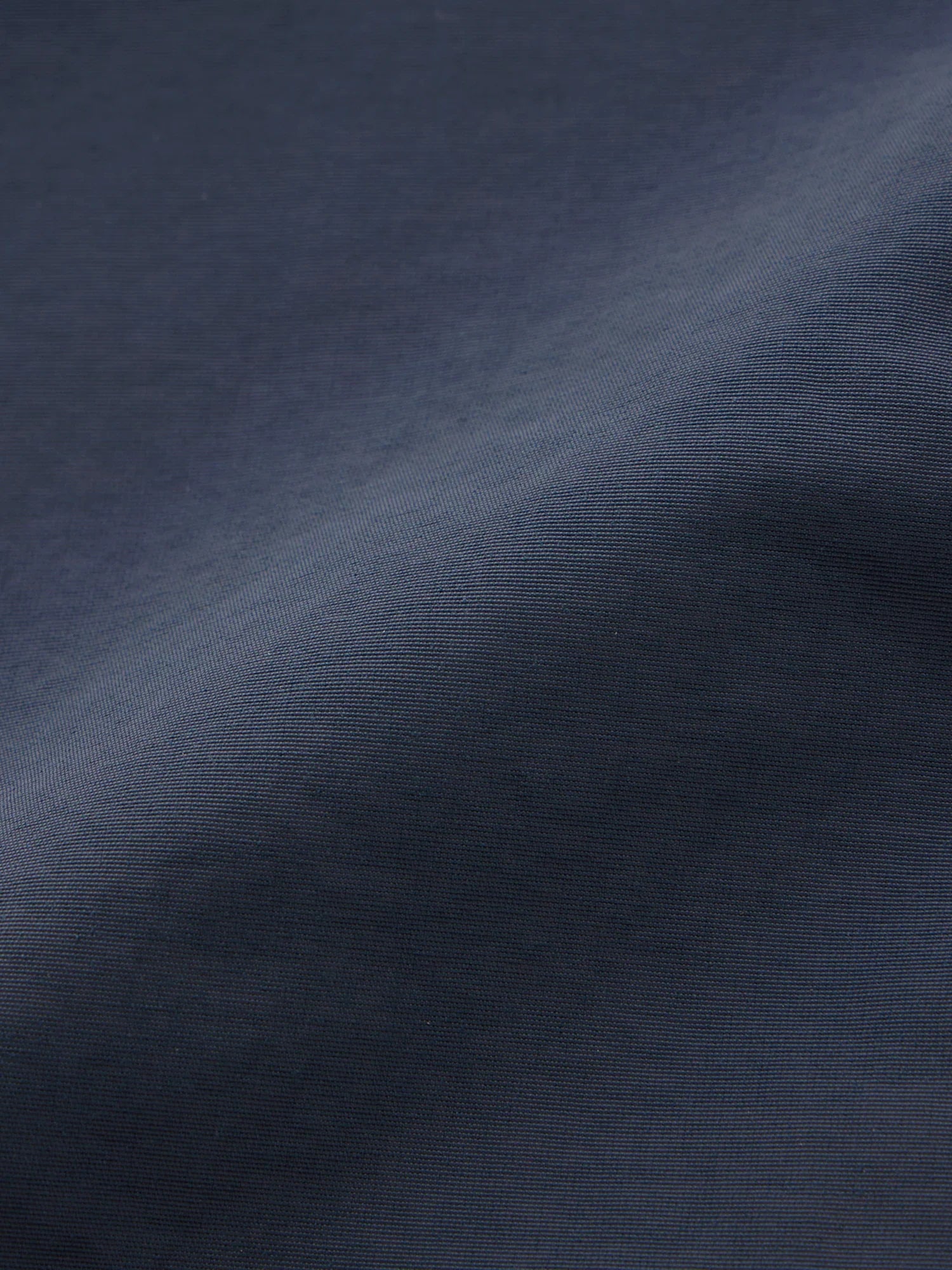 Close-up of smooth navy blue polyester fabric texture with fine weave