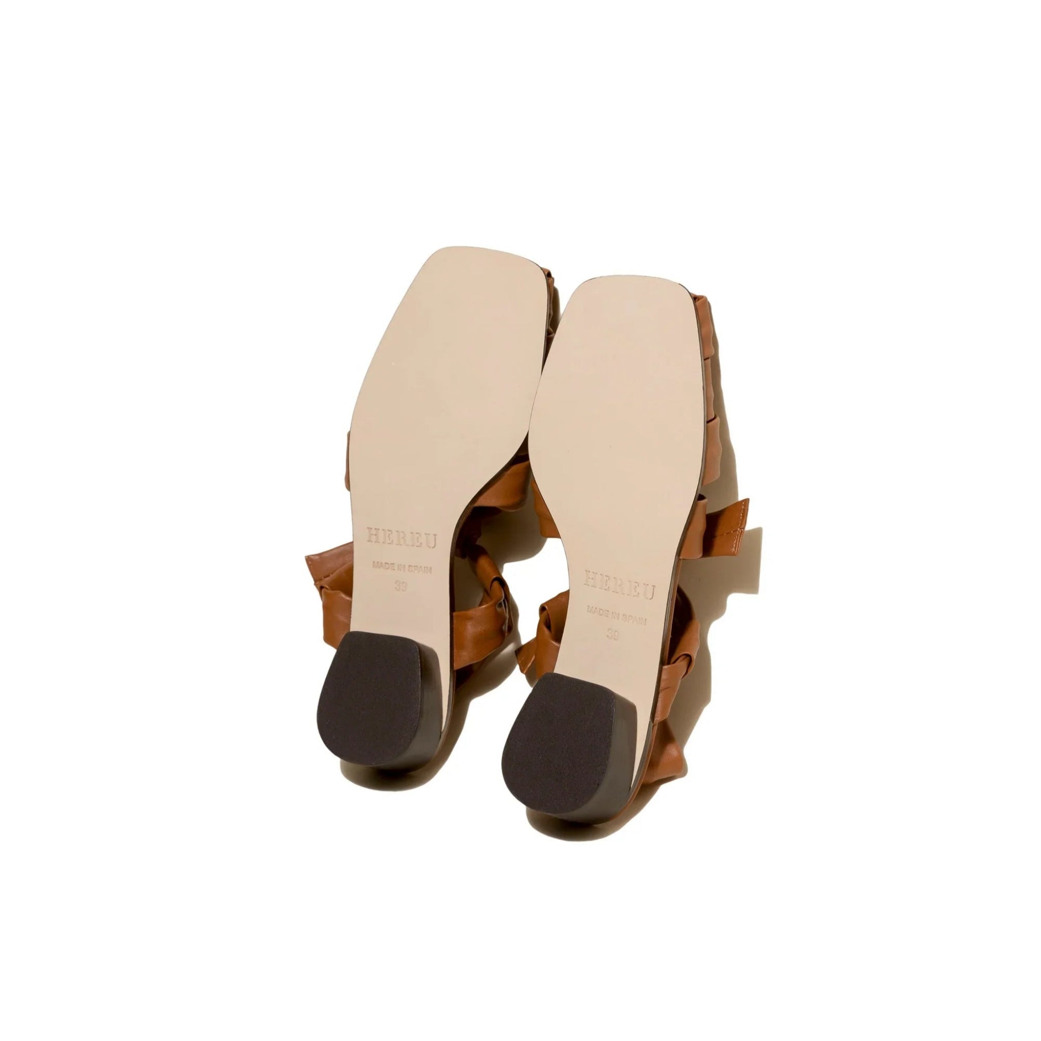 Bottom view of brown leather heeled sandals with HERREU branding and size 39 on beige sole