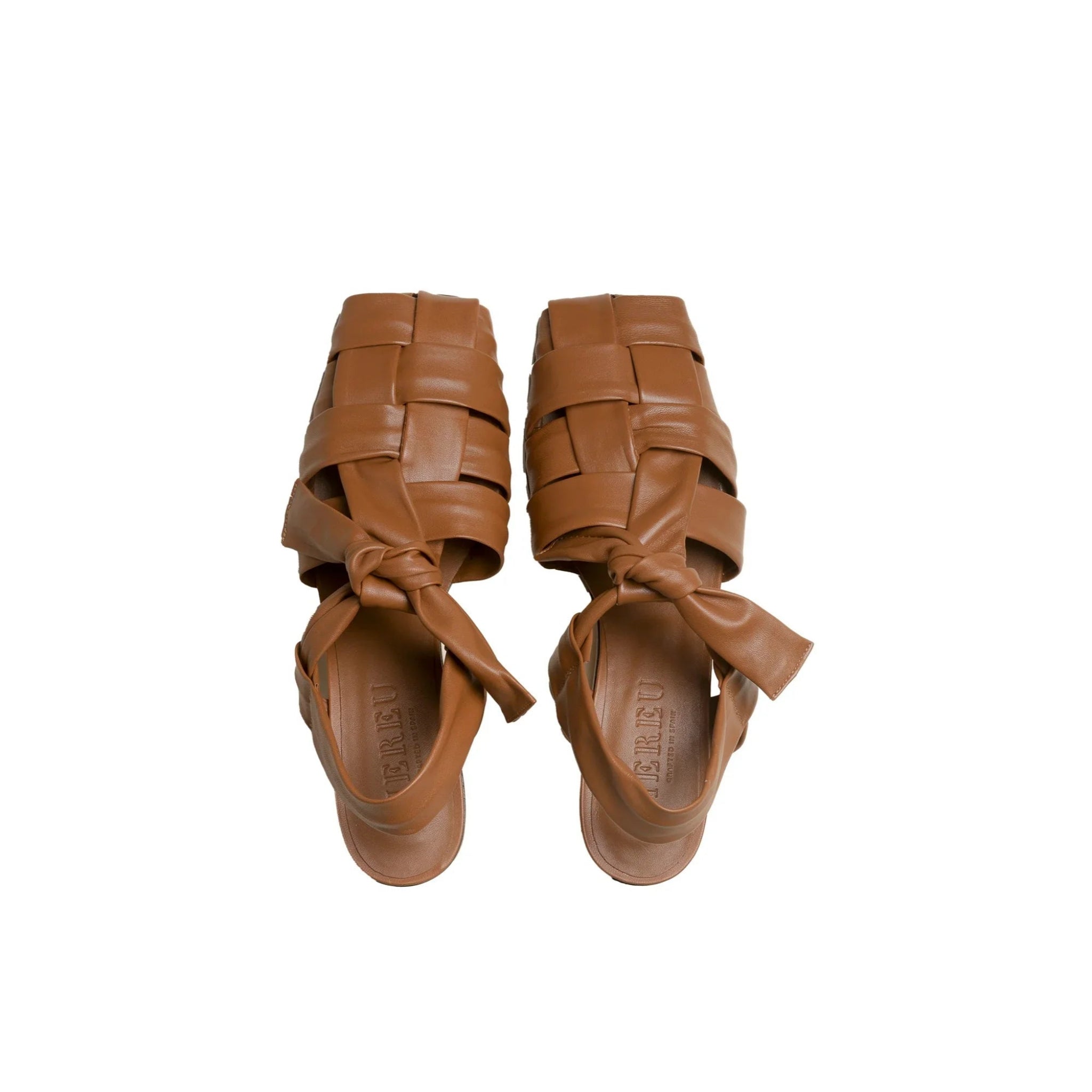 Pair of brown woven leather heeled sandals with knotted straps on white background