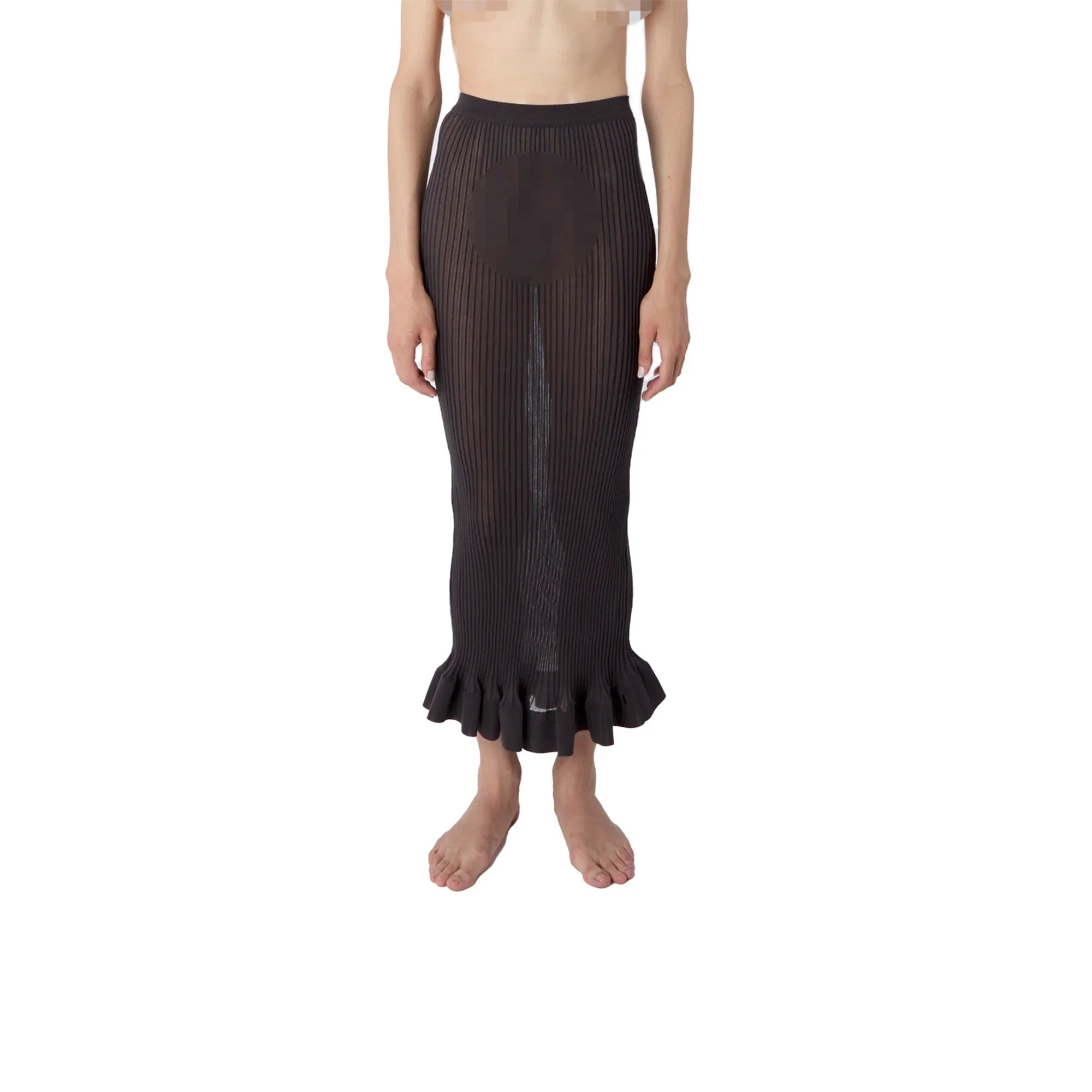 Woman wearing black ribbed knit midi skirt with ruffled hem, posing barefoot on white background