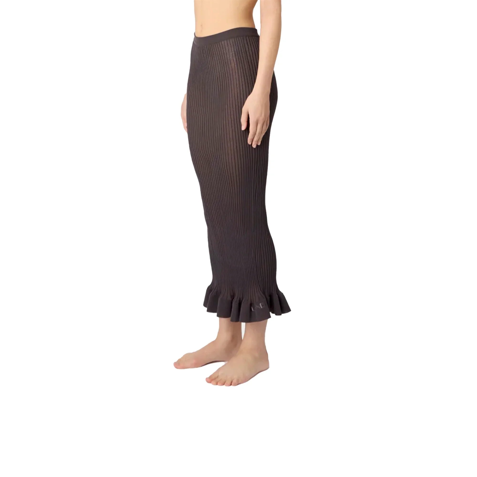 Side view of woman wearing a dark brown ribbed knit long skirt with ruffle hem