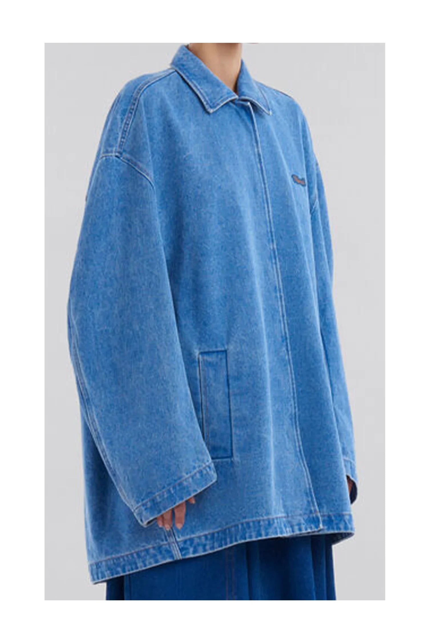 Oversized light blue denim jacket with collar and front pockets worn by model
