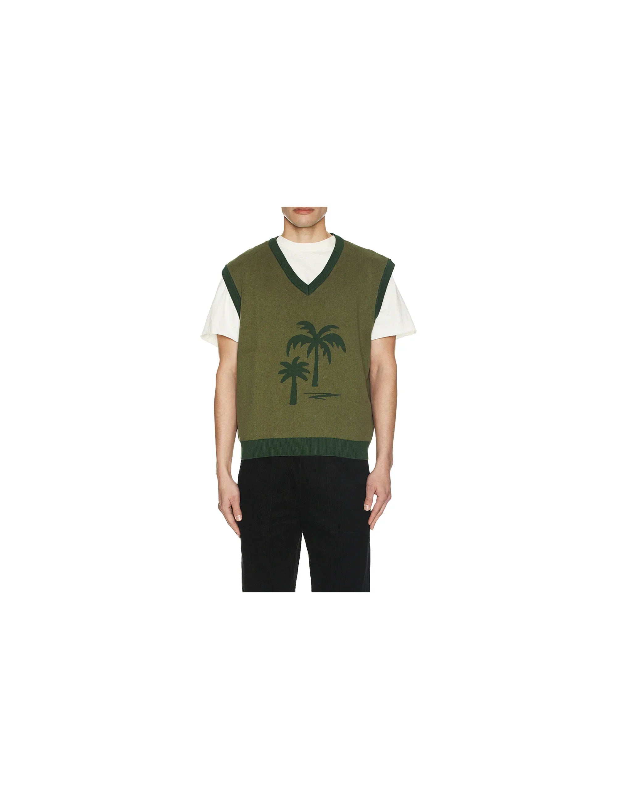 Model wearing olive green sleeveless sweater vest with dark green palm tree graphic over white t-shirt