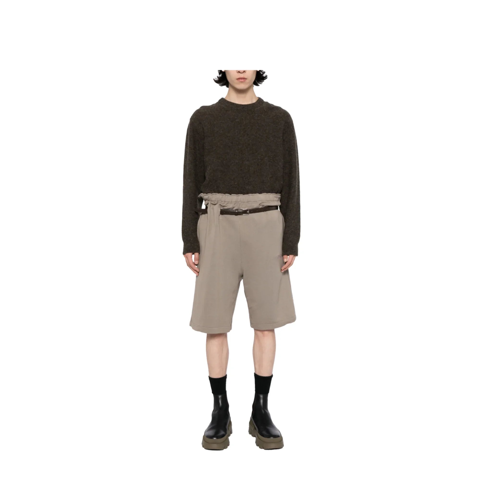 Model wearing beige paperbag waist athletic shorts with black belt, dark sweater, and black boots