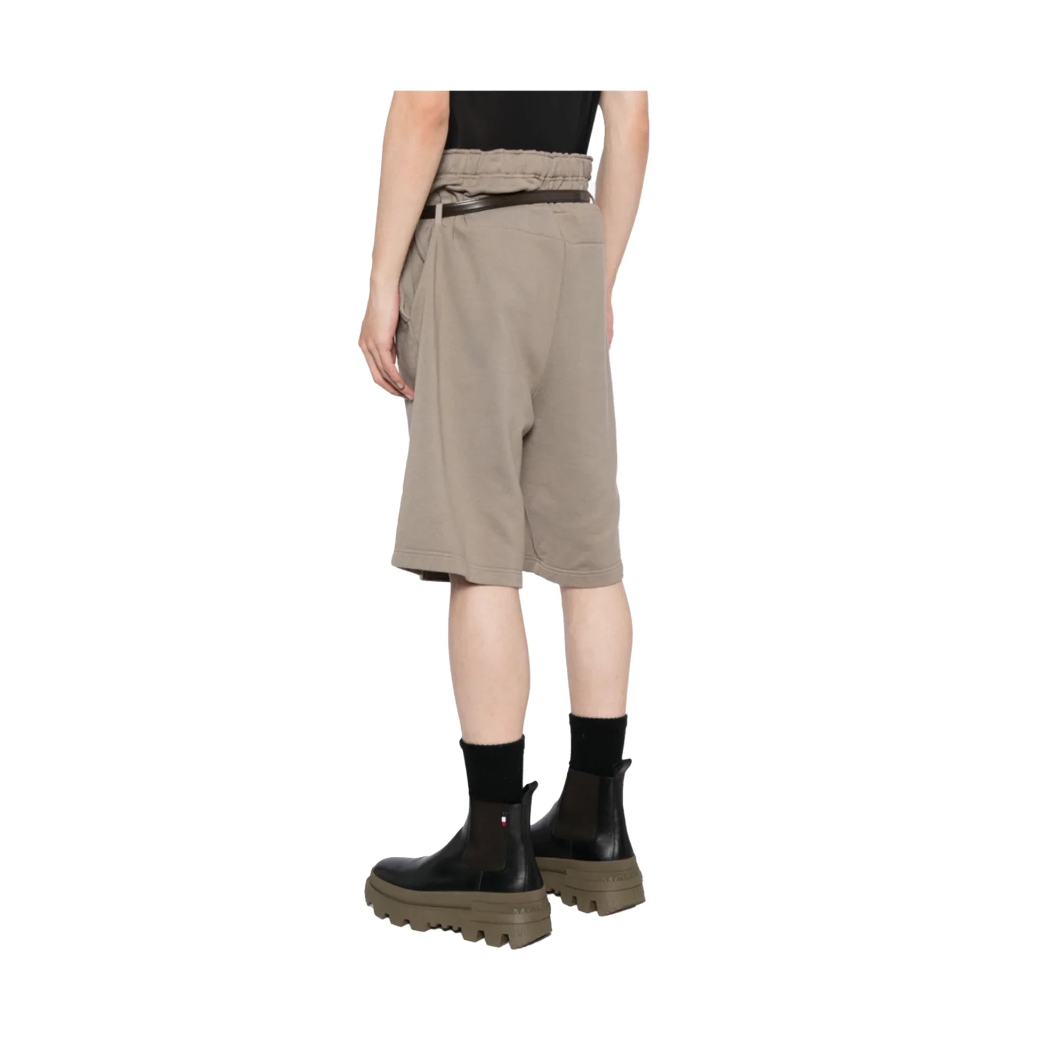 Back view of person wearing taupe athletic shorts with elastic waistband and black boots
