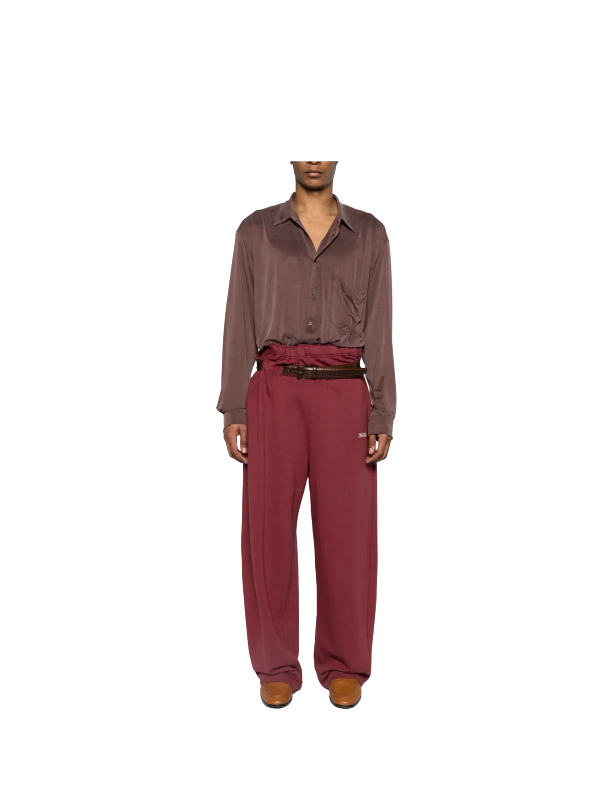 Model wearing brown silk shirt and burgundy paperbag waist trackpants with belt and tan shoes