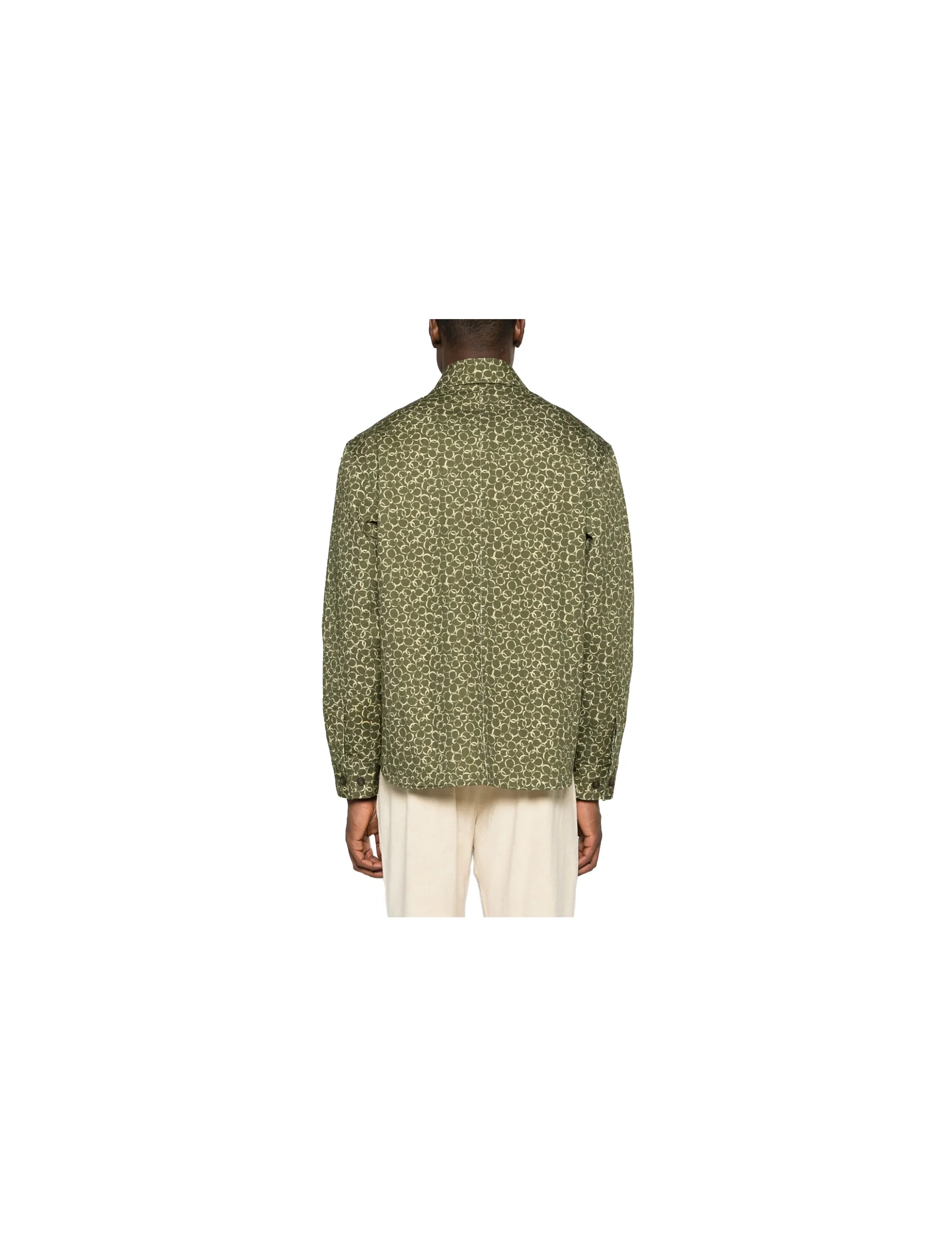 Back view of a model wearing a green patterned long-sleeve shirt with beige pants