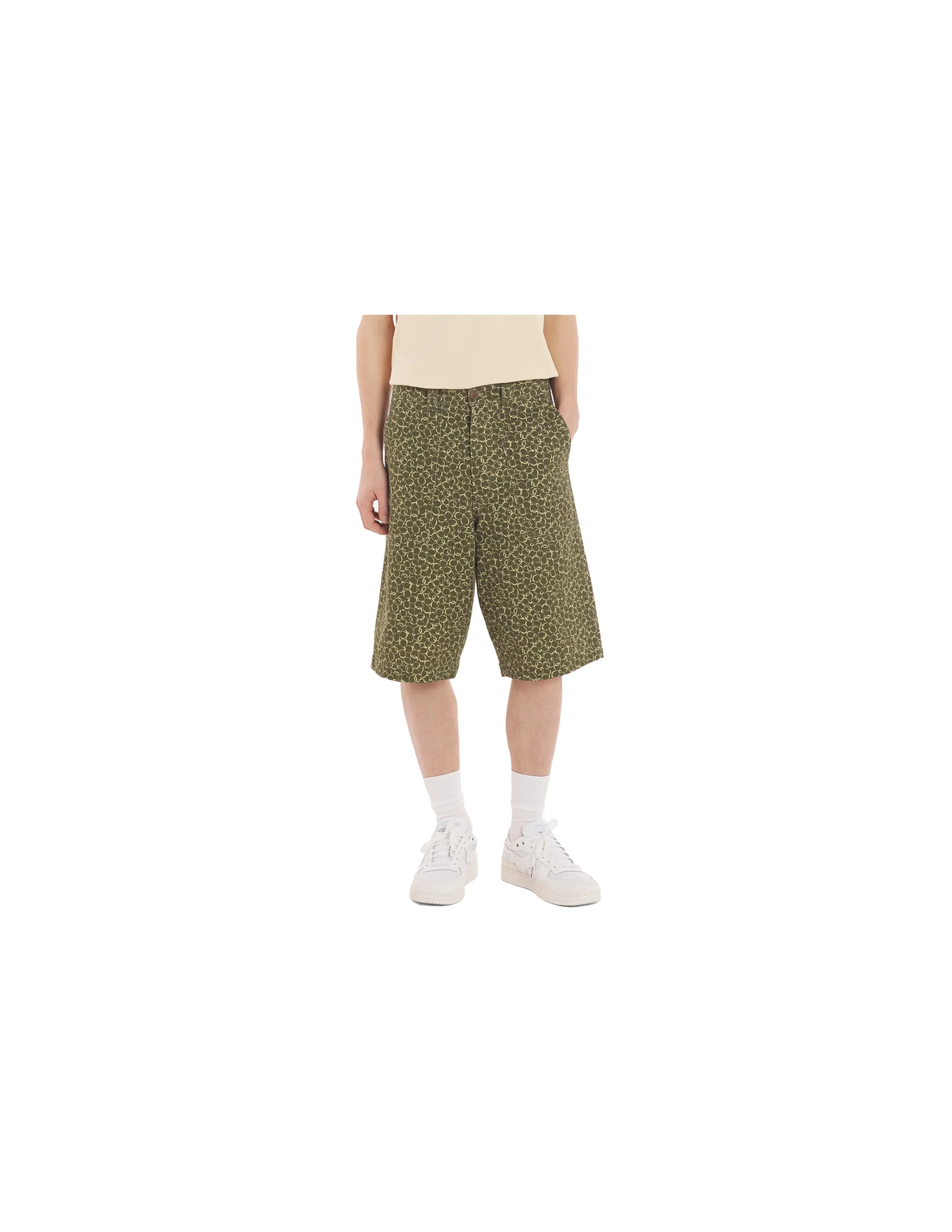 Male model wearing olive green patterned workwear bermuda shorts with white sneakers and socks