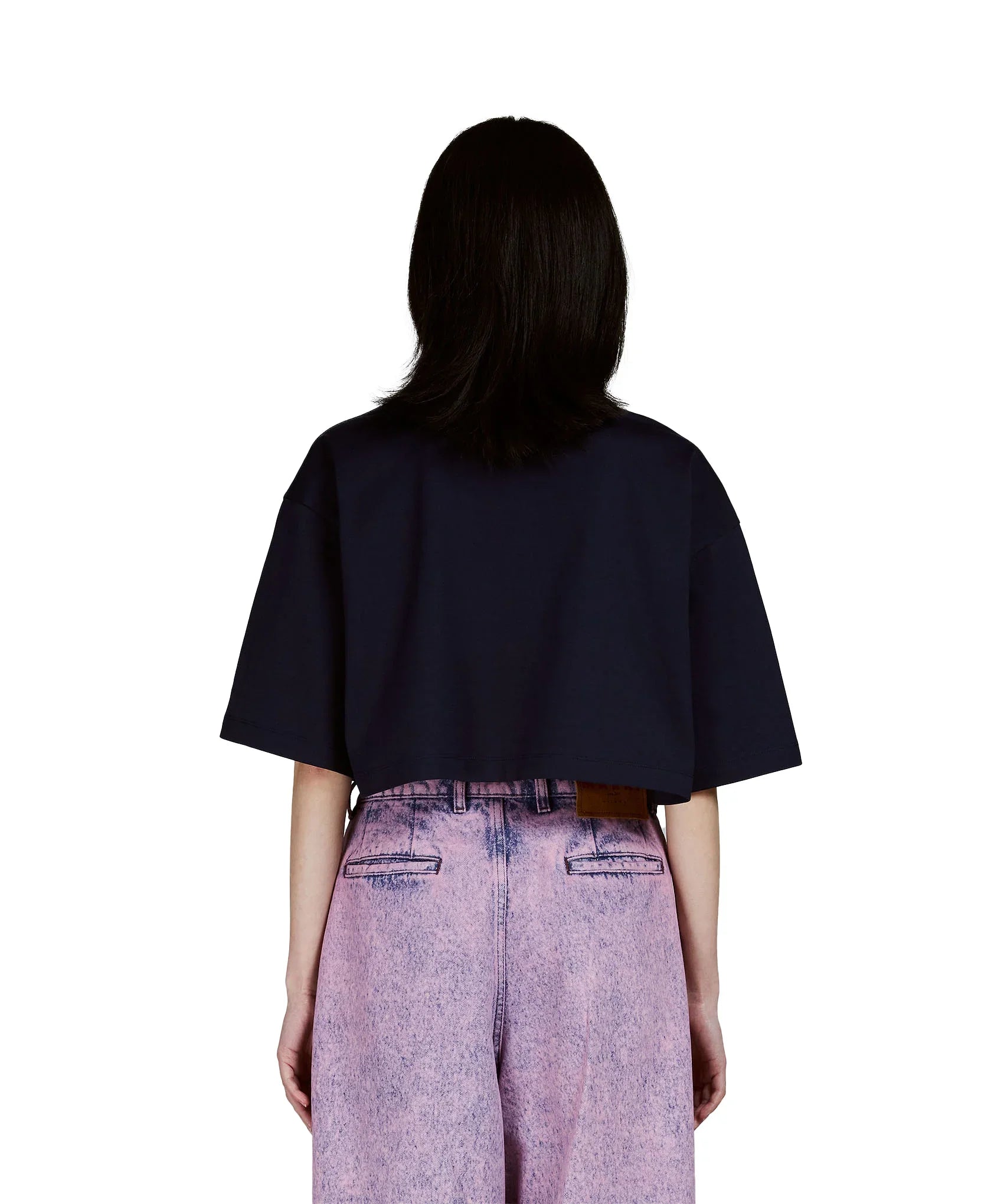 Back view of person wearing a black cropped t-shirt and high-waisted pink acid-wash jeans