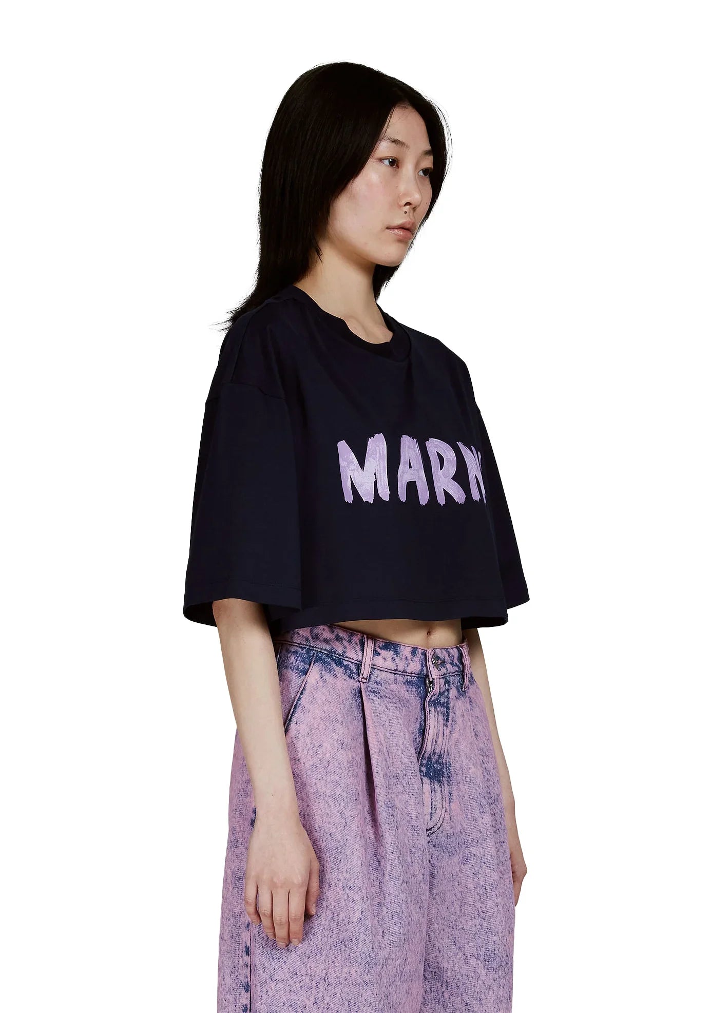 Woman wearing black cropped T-shirt with MARNI logo paired with high-waisted pink acid-wash jeans