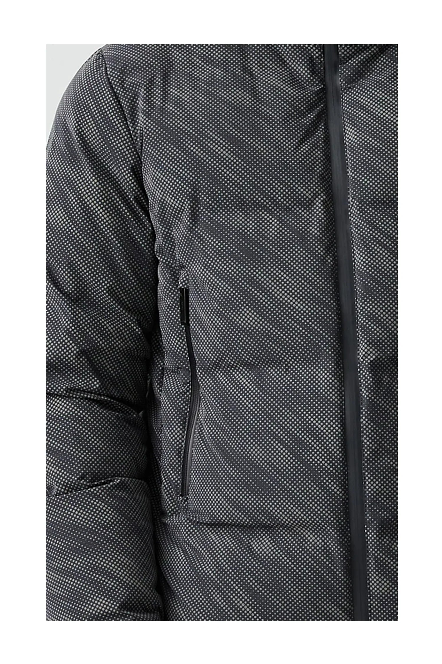 Close-up of black and white dotted puffer jacket with zippered pocket and front zipper