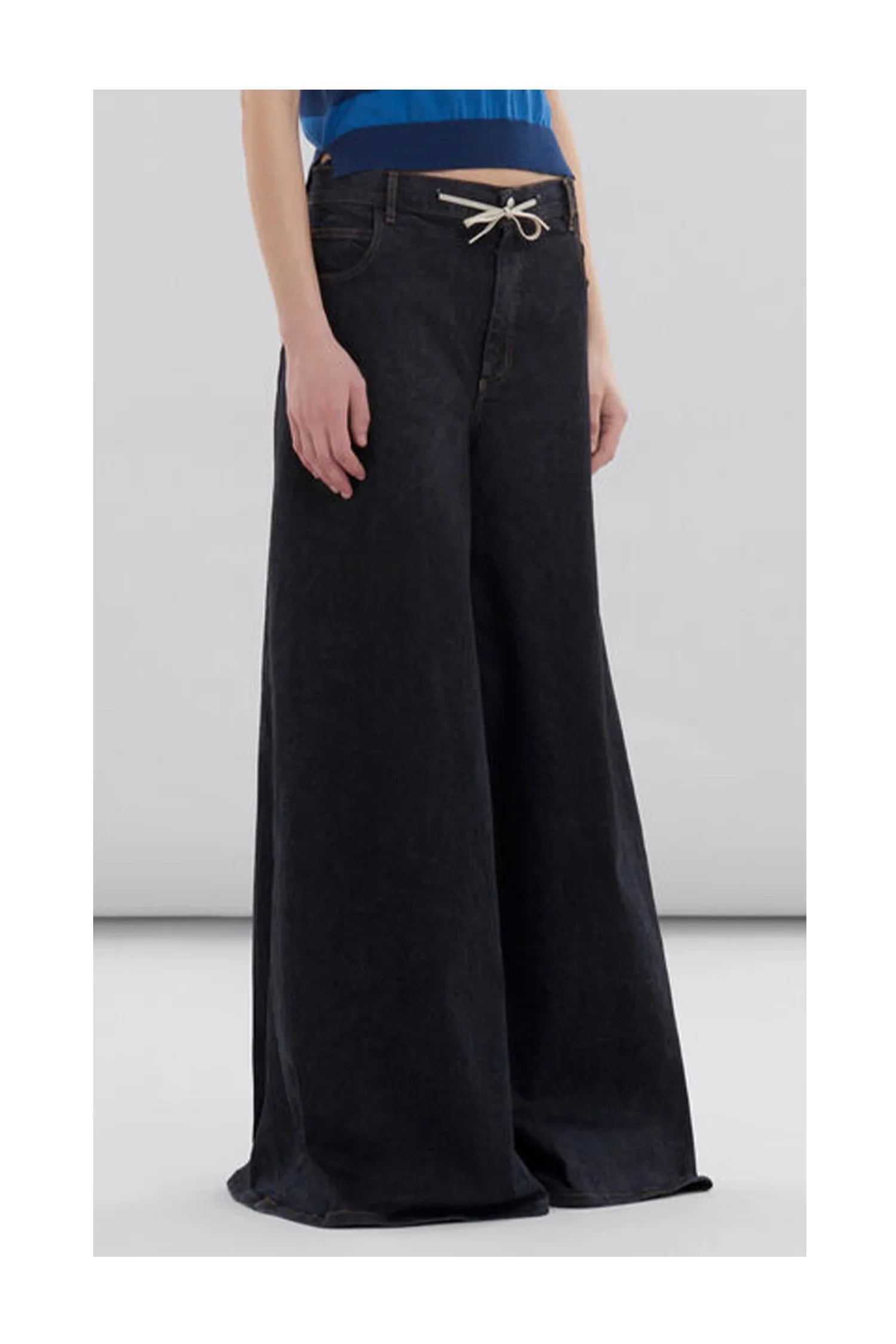 Wide-leg black denim jeans with white drawstring detail, worn with a blue top