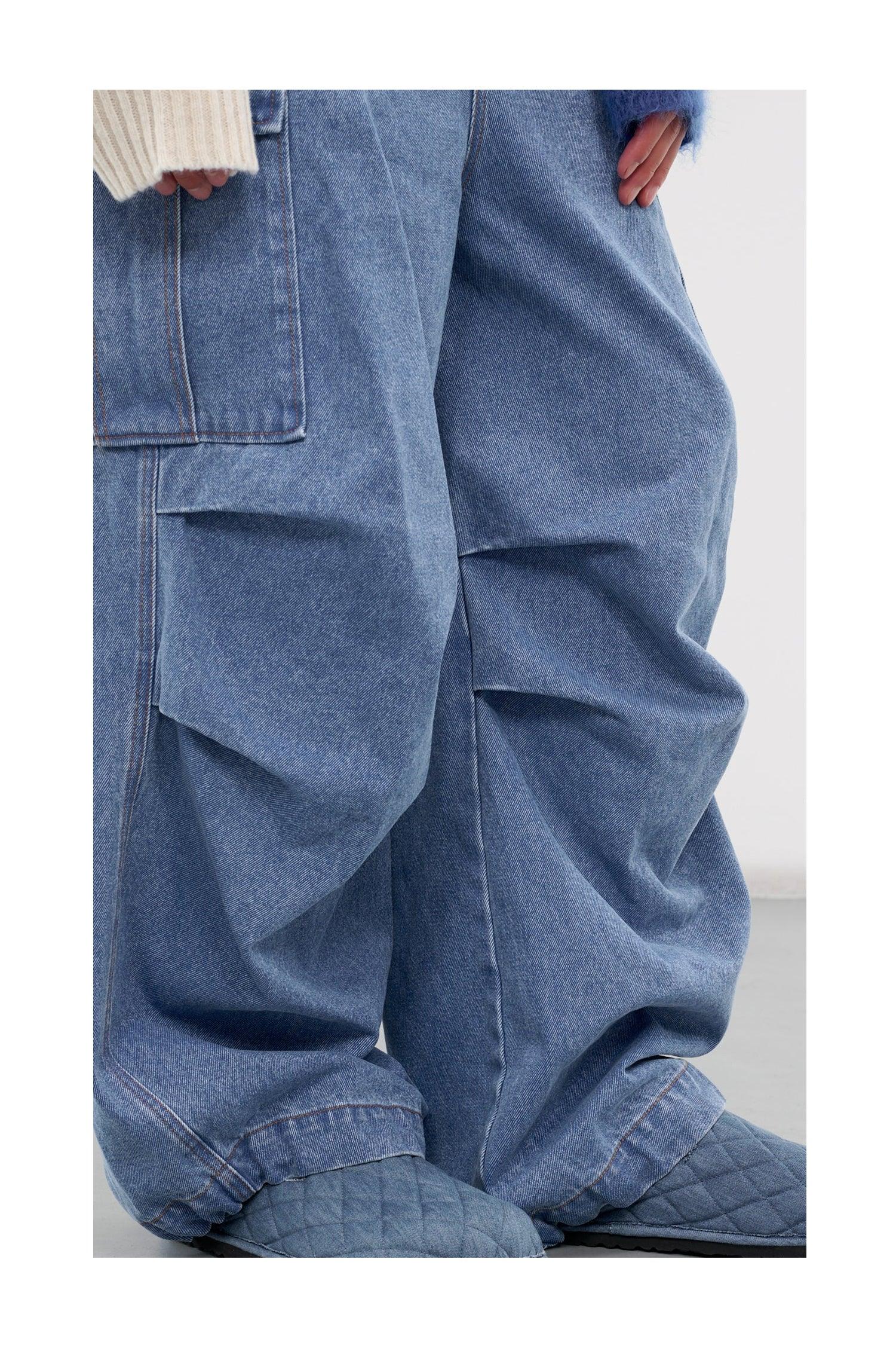 Close-up of baggy blue denim jeans with patch pockets and quilted blue slippers