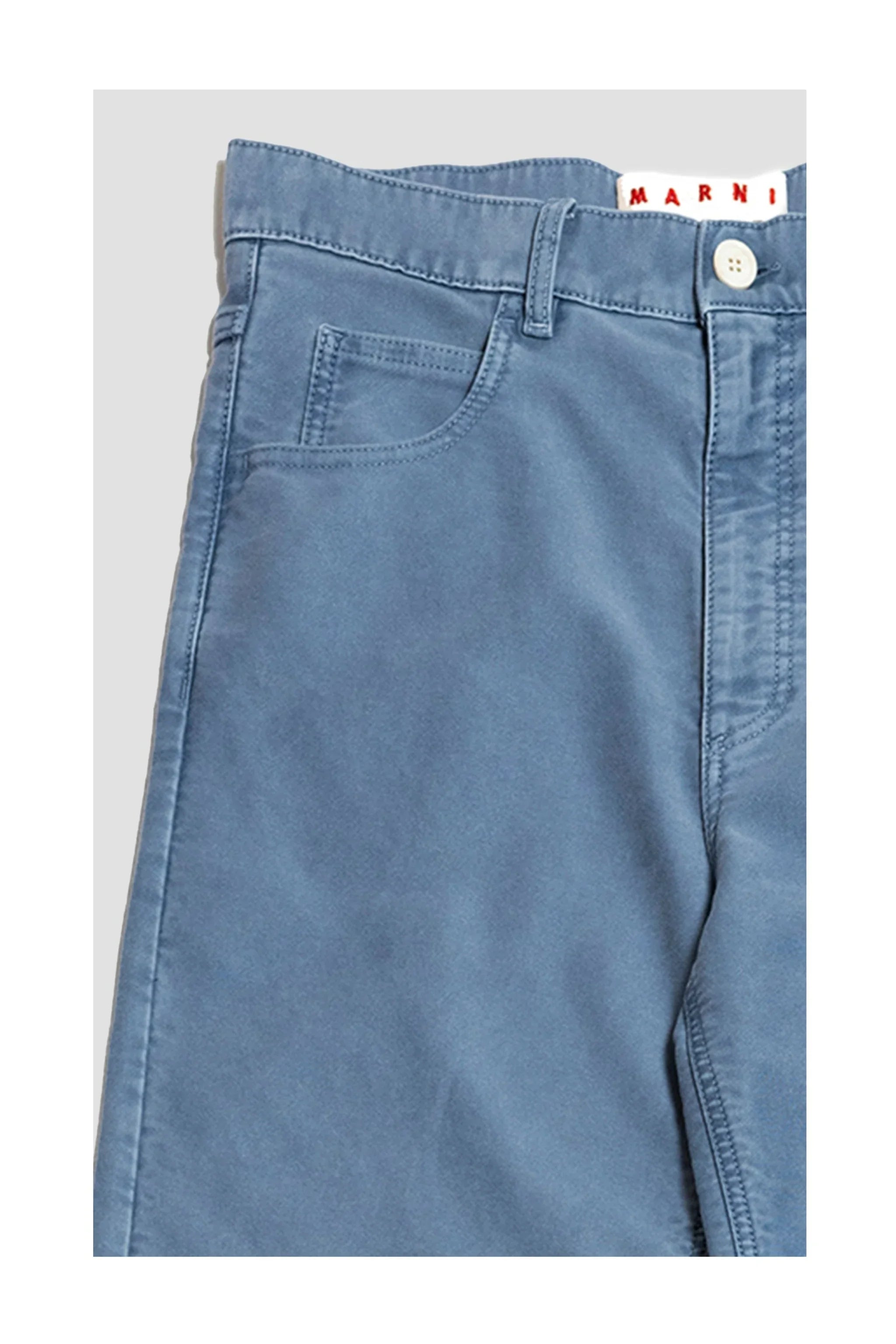 Close-up of blue Marni pants with front pocket and white button closure