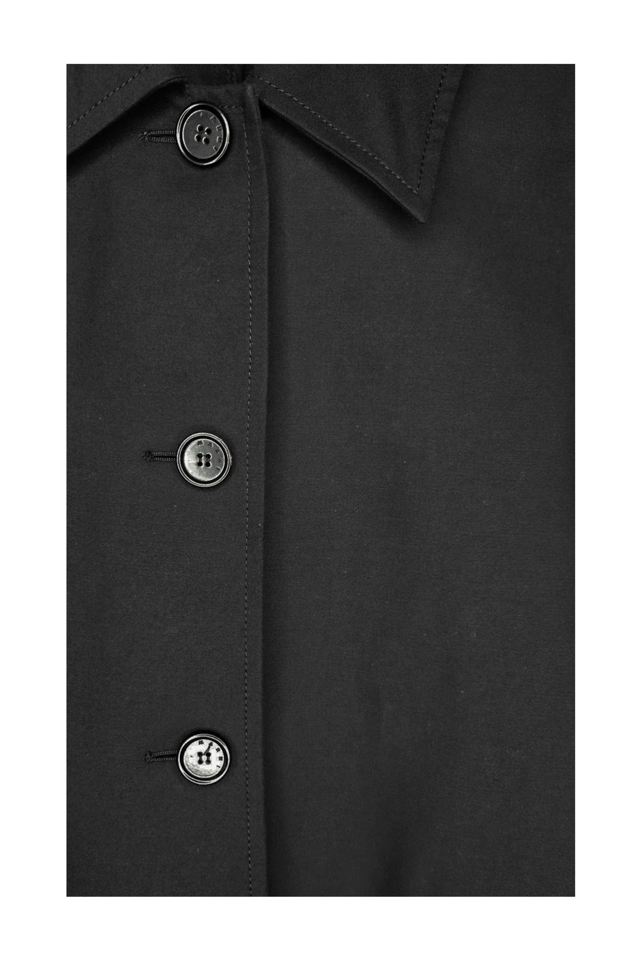 Close-up of a black coat with buttons on a white background
