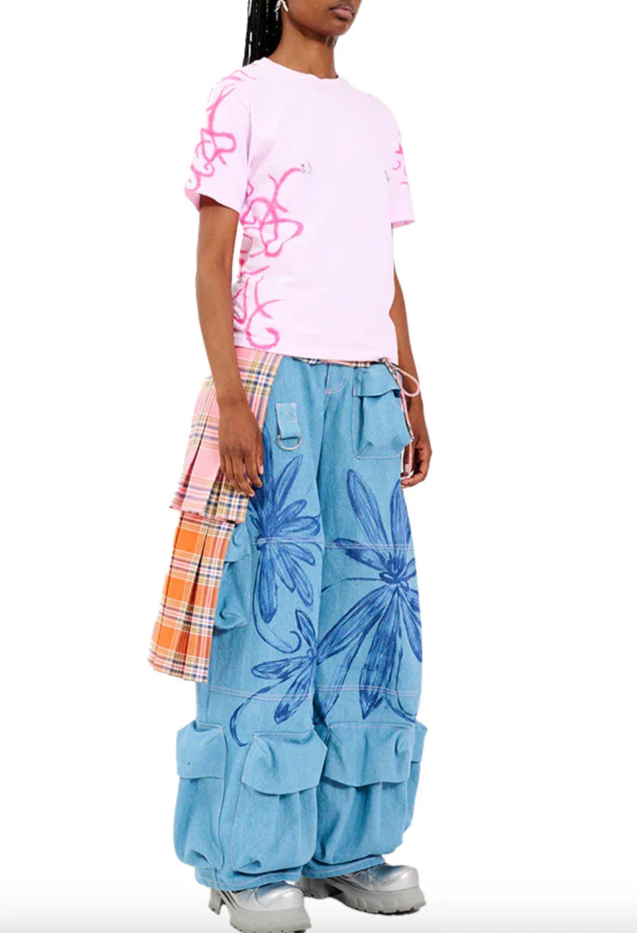 Model wearing pink graphic t-shirt paired with blue wide-leg floral print pants and plaid side panels