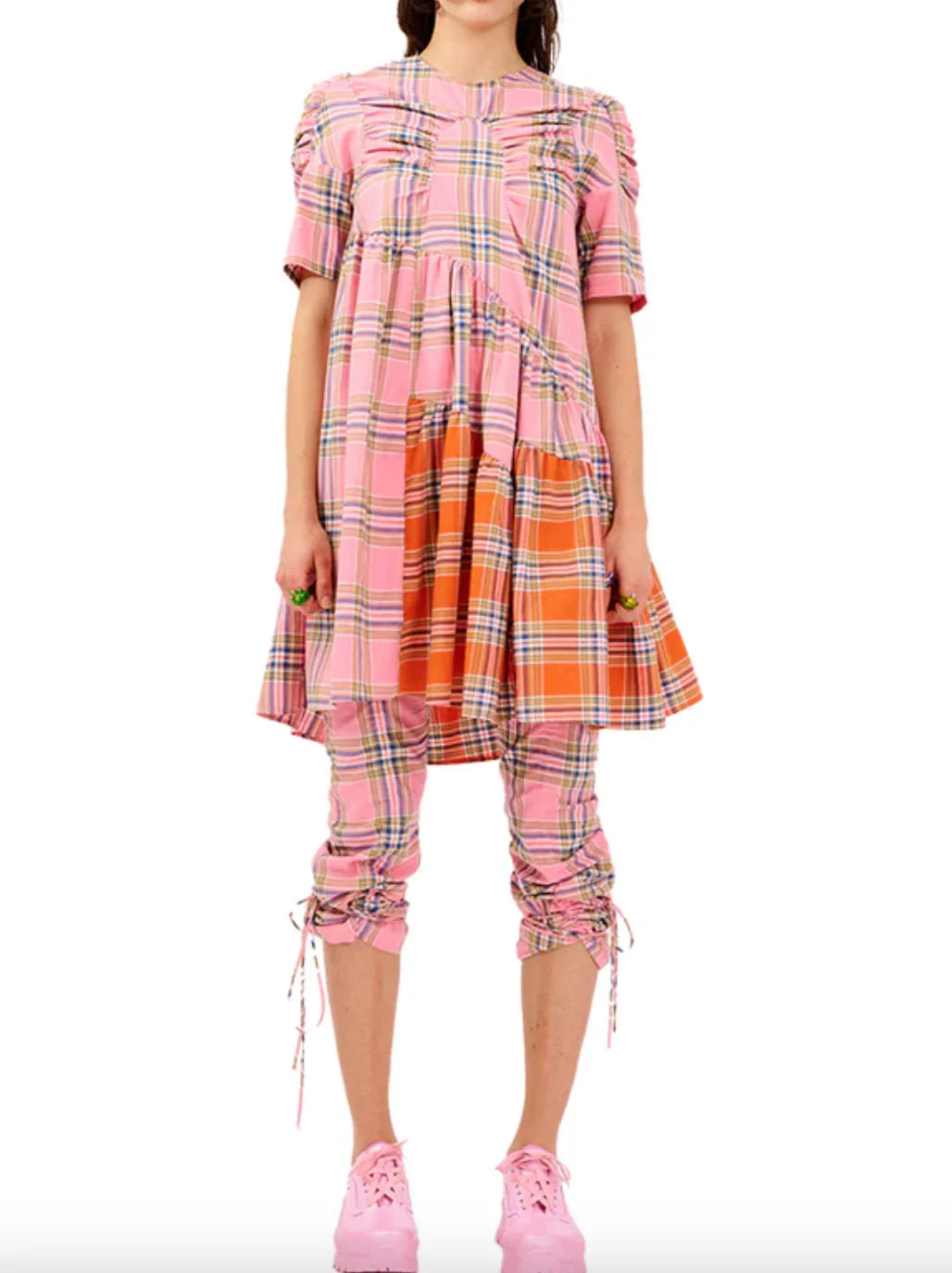 Woman wearing pink and orange plaid dress with ruched short sleeves and matching cropped pants