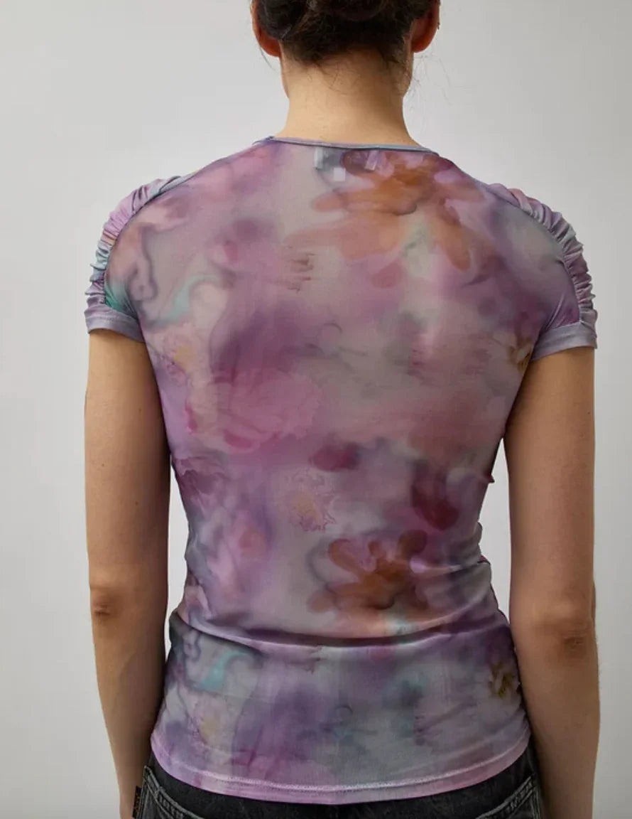 Back view of person wearing sheer purple floral mesh top with ruched sleeves