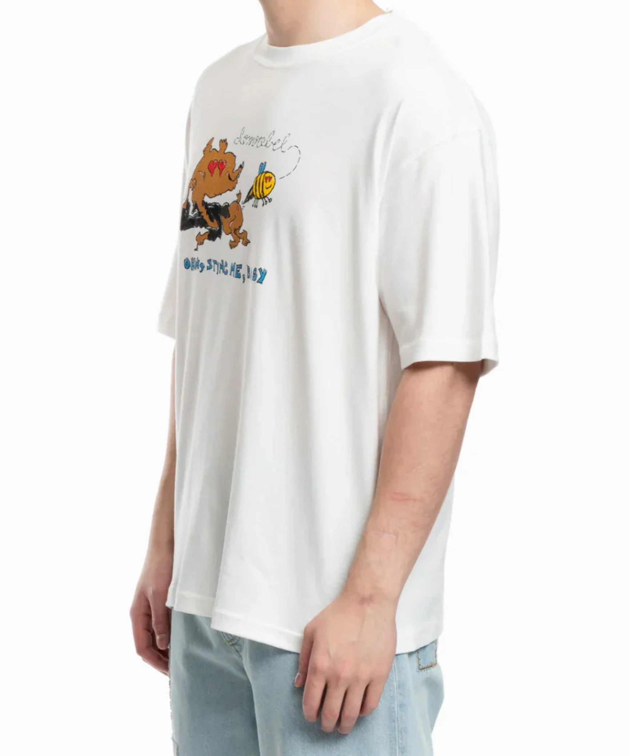 White short-sleeve t-shirt with cartoon dog and bee graphic, worn with light blue jeans