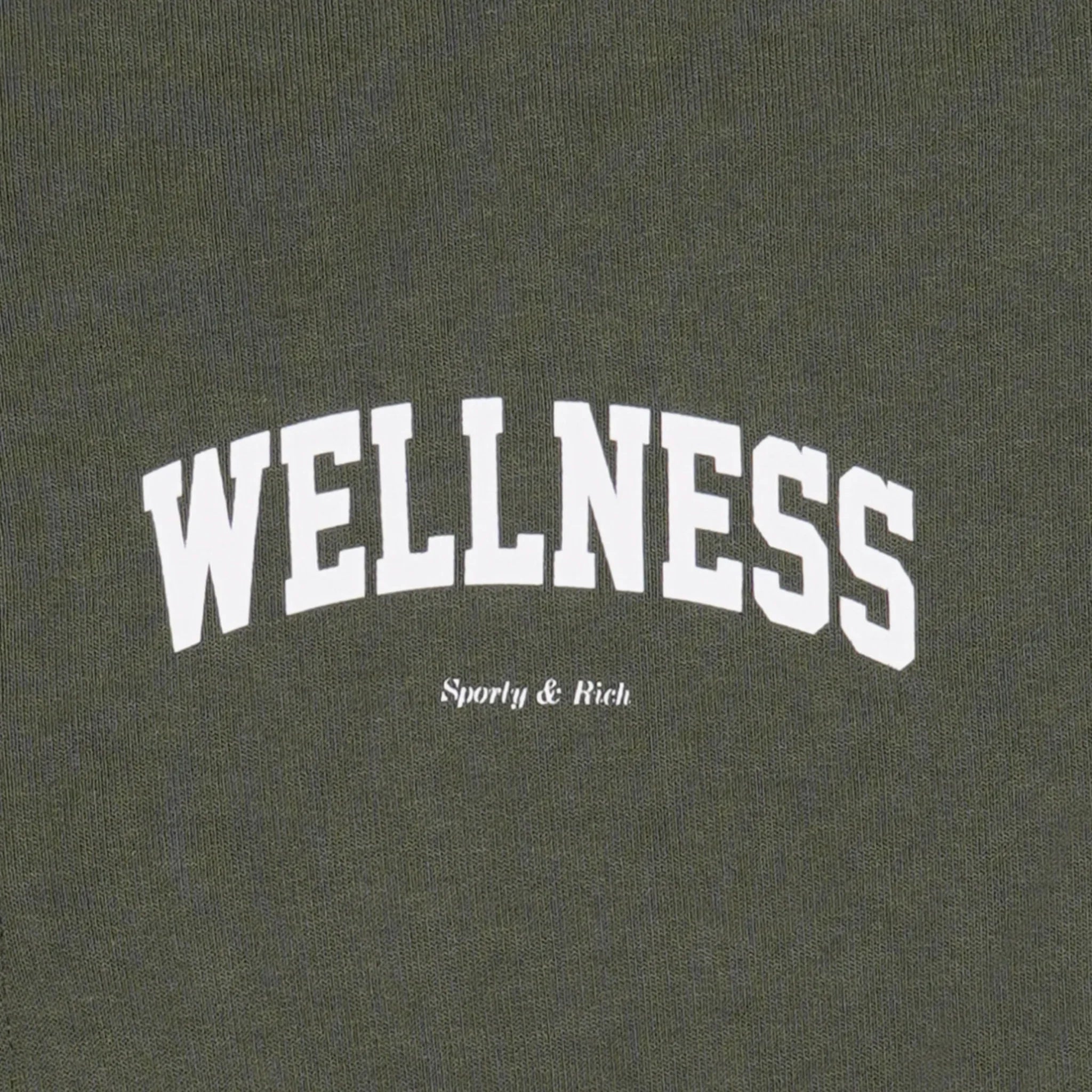 Olive green fabric with white text 'WELLNESS' and smaller text 'Sporty & Rich' printed on it